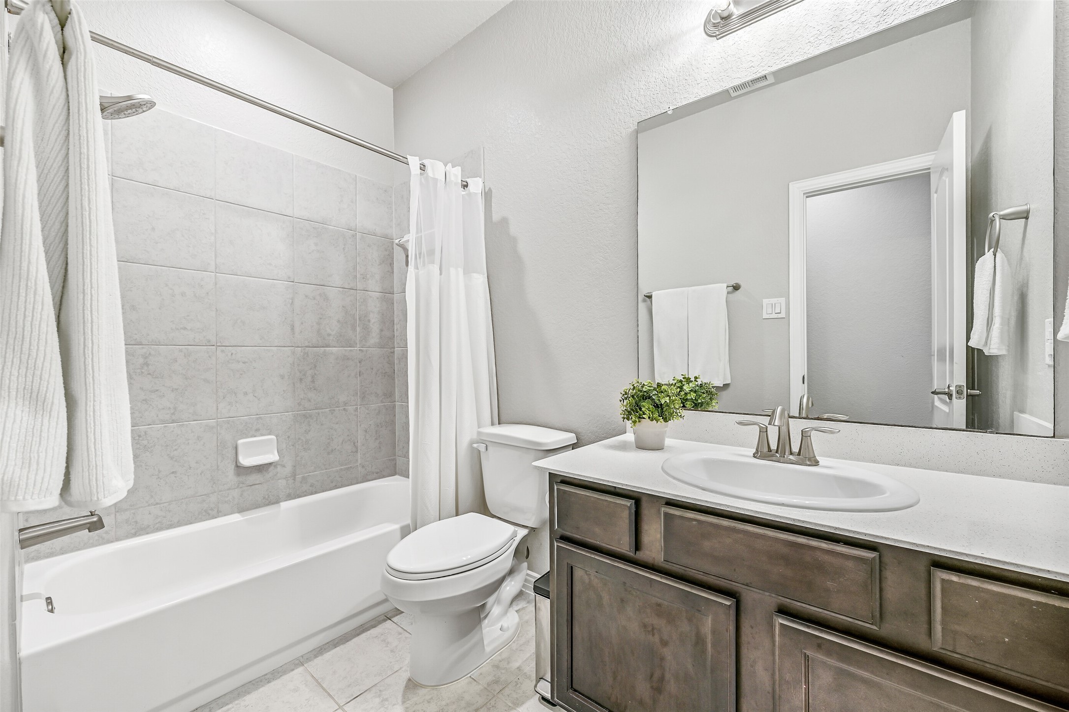 The nearby secondary bathroom serves the additional bedrooms with a spacious vanity, ample storage, and a tub/shower combination. Neutral finishes make it easy to personalize while providing everyday functionality.