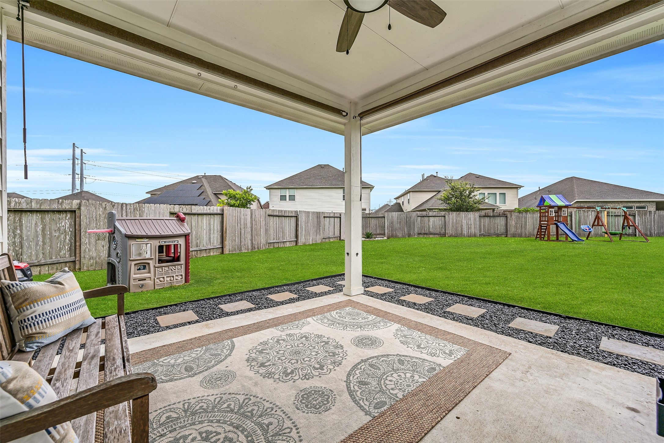 The covered back patio is ready for year-round enjoyment with a ceiling fan, plenty of room for outdoor seating, and peaceful views across the expansive backyard. It's the perfect place to enjoy morning coffee while watching kids and pets play.