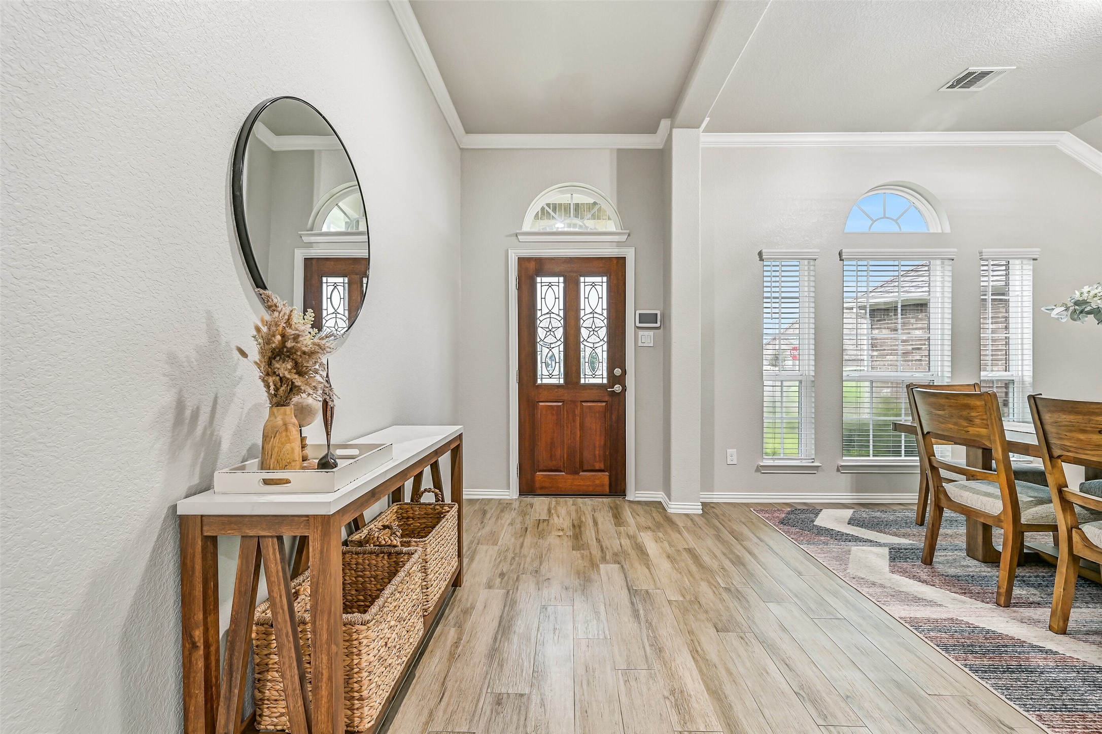 Looking back toward the entry, you'll appreciate the abundance of natural light pouring through the transom window and tall front windows. Crown molding and updated finishes create a clean, move-in-ready first impression. Looking back toward the entry, you'll appreciate the abundance of natural light pouring through the transom window and tall front windows. Crown molding and updated finishes create a clean, move-in-ready first impression.