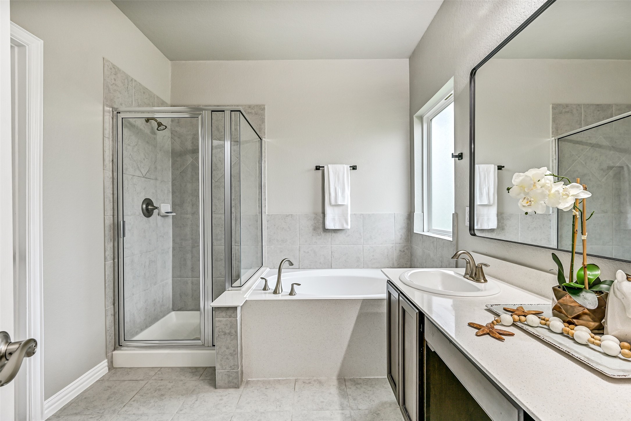 Designed for relaxation, the primary bath also includes a soaking tub, separate glass-enclosed shower, and private water closet. Thoughtful finishes and a functional layout create a comfortable space to begin and end each day.