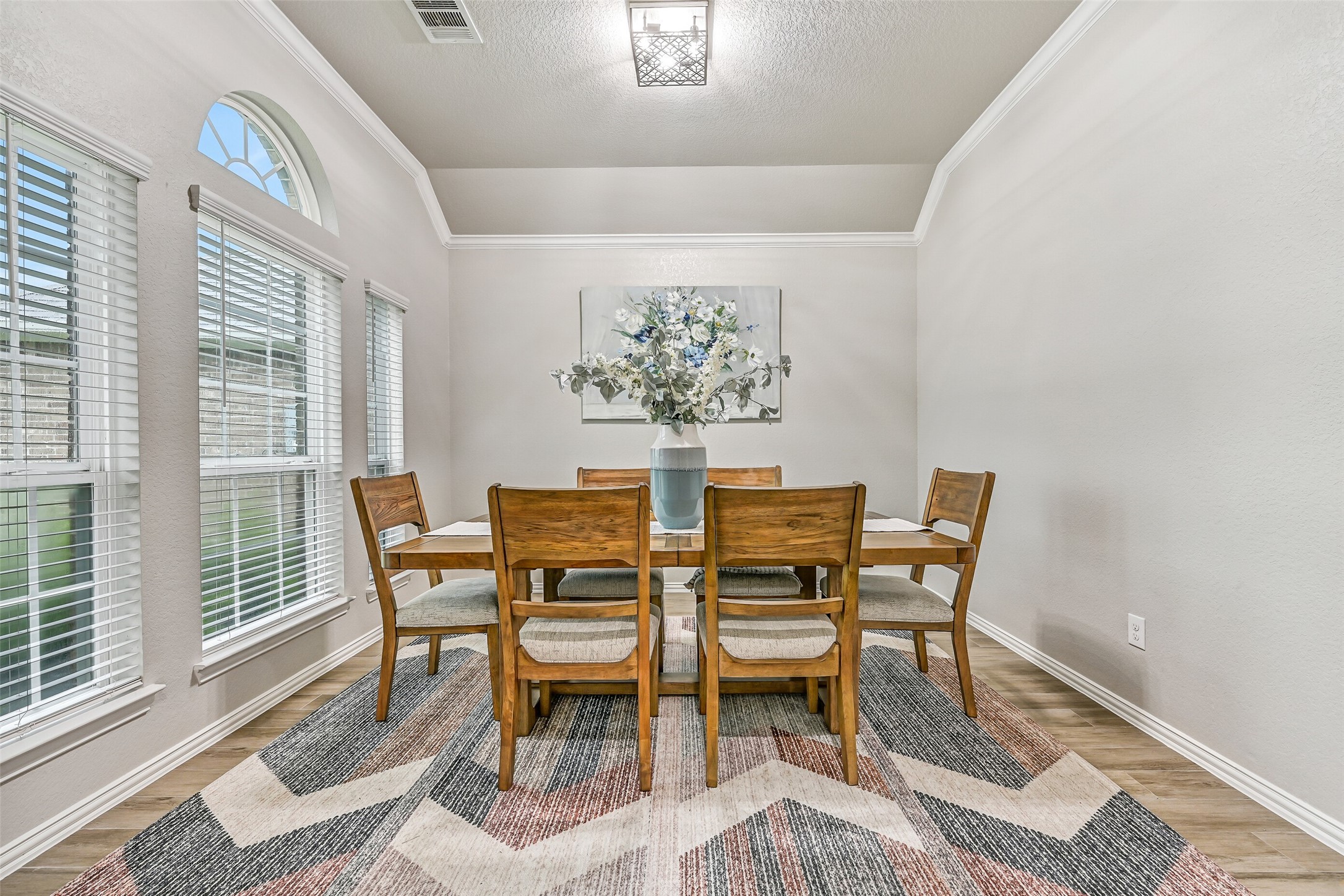 Just off the foyer, the formal dining room offers an elegant setting for family dinners and holiday gatherings. Elevated ceilings, crown molding, and oversized windows make this flexible space feel bright, open, and inviting. Just off the foyer, the formal dining room offers an elegant setting for family dinners and holiday gatherings. Elevated ceilings, crown molding, and oversized windows make this flexible space feel bright, open, and inviting.