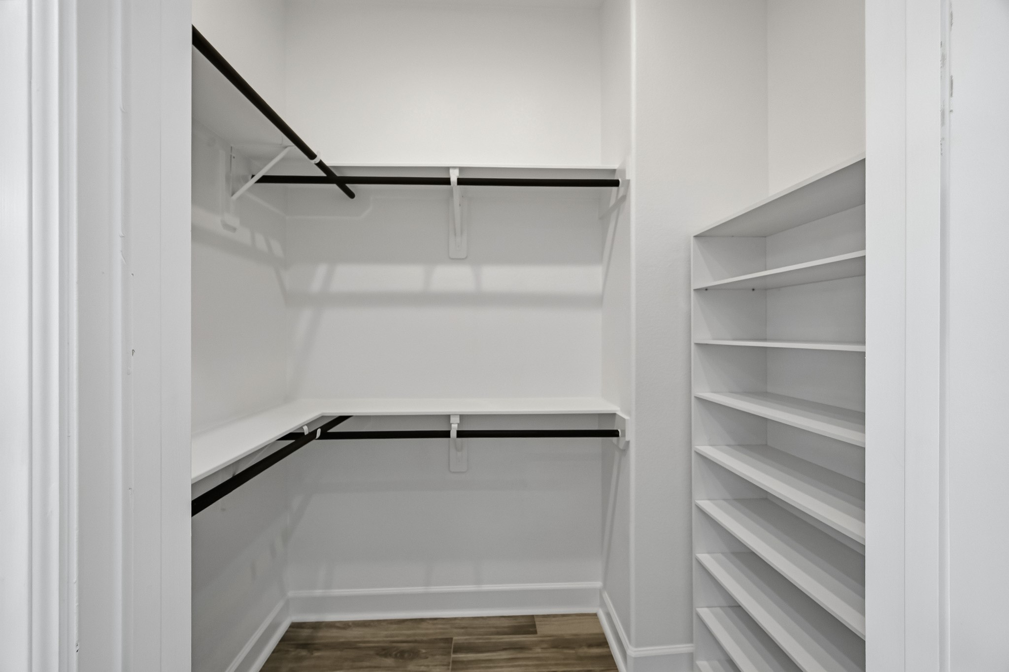 Floor-to-ceiling organization and generous proportions define this highly functional dressing retreat. Multi-level hanging rods and modular shelving maximize usable square footage while maintaining an open, accessible spatial flow.