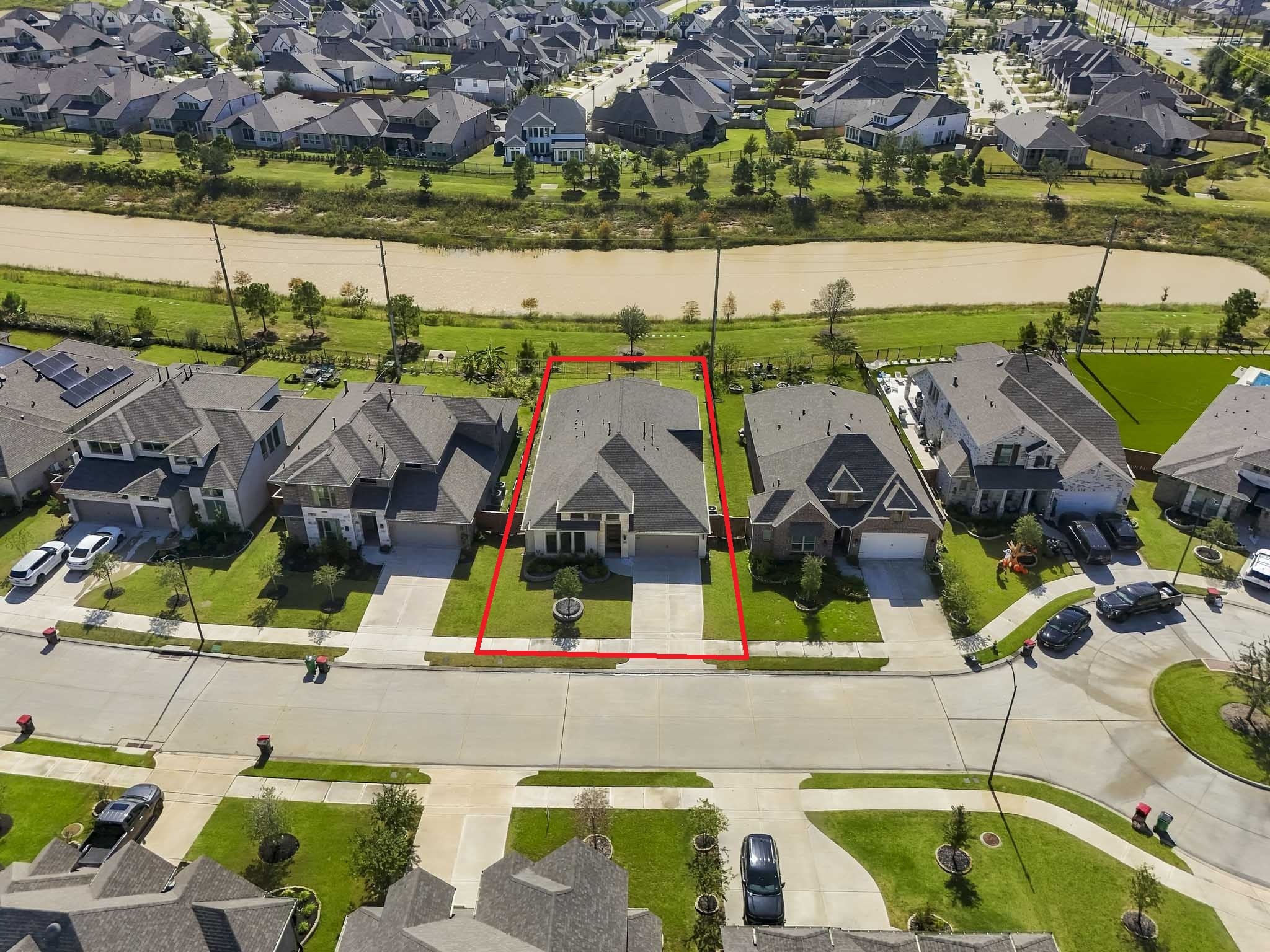 Highlighting the level grass areas, perimeter fencing, and the front entry off a suburban street, this perspective offers a clear sense of the property's proportions, setback, and peaceful scenic backdrop.