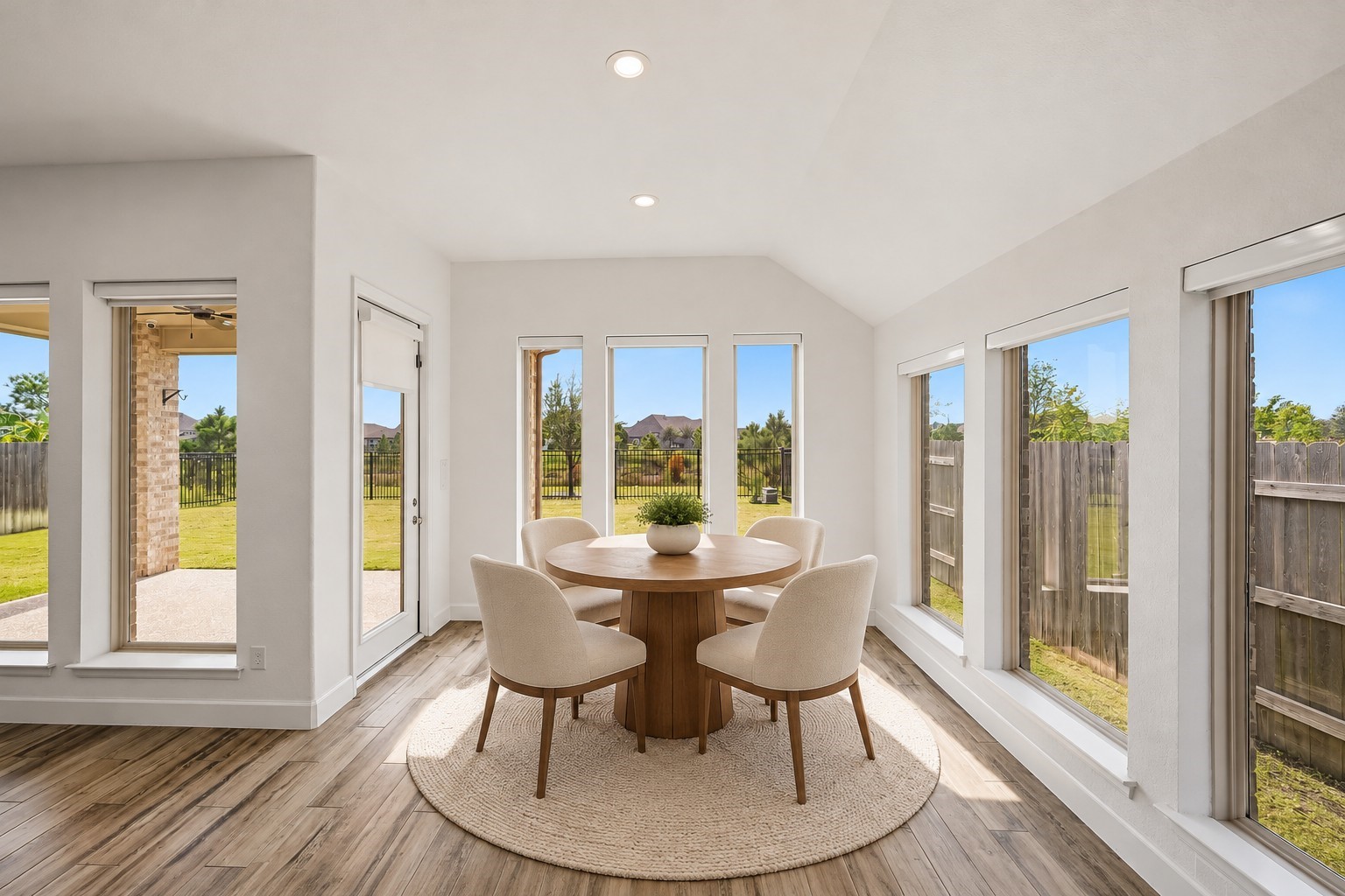 Virtually Staged: Encircled by expansive windows, this sunlit alcove offers a bright, open feel with a seamless view of the outdoors.
