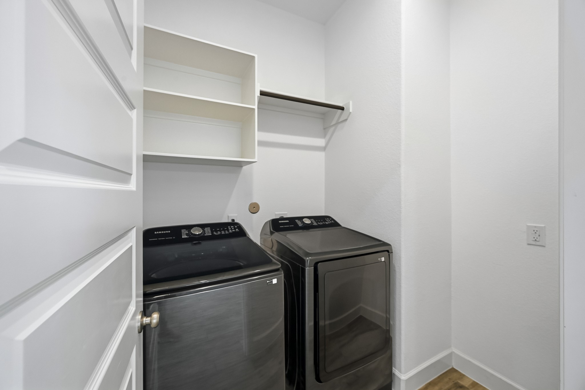 Step into a well-proportioned utility room that blends smart structural organization with an airy, open feel. Generous vertical height and built-in shelving offer exceptional utility within an uncluttered, purposeful design.