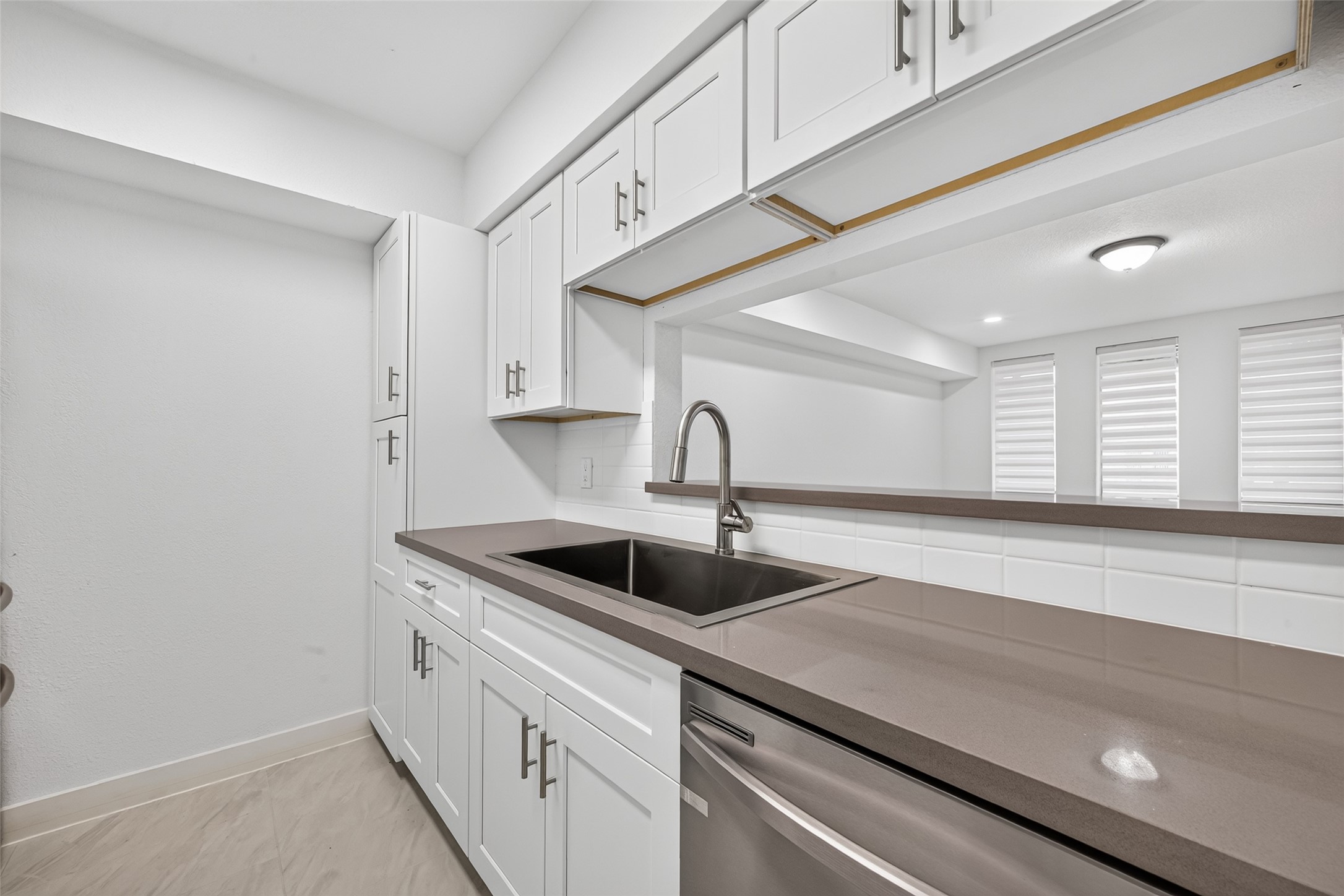Everyday functionality meets contemporary design with new cabinetry, quartz countertops, a 33-inch single-bowl sink, and a timeless neutral finish.