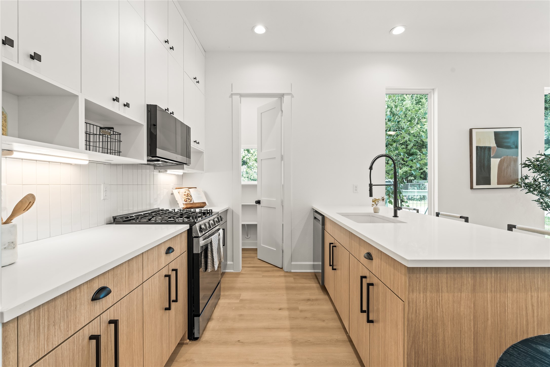 White upper cabinets, warm wood lowers a kitchen built with contrast in mind, equally with storage maximization. White upper cabinets, warm wood lowers a kitchen built with contrast in mind, equally with storage maximization.