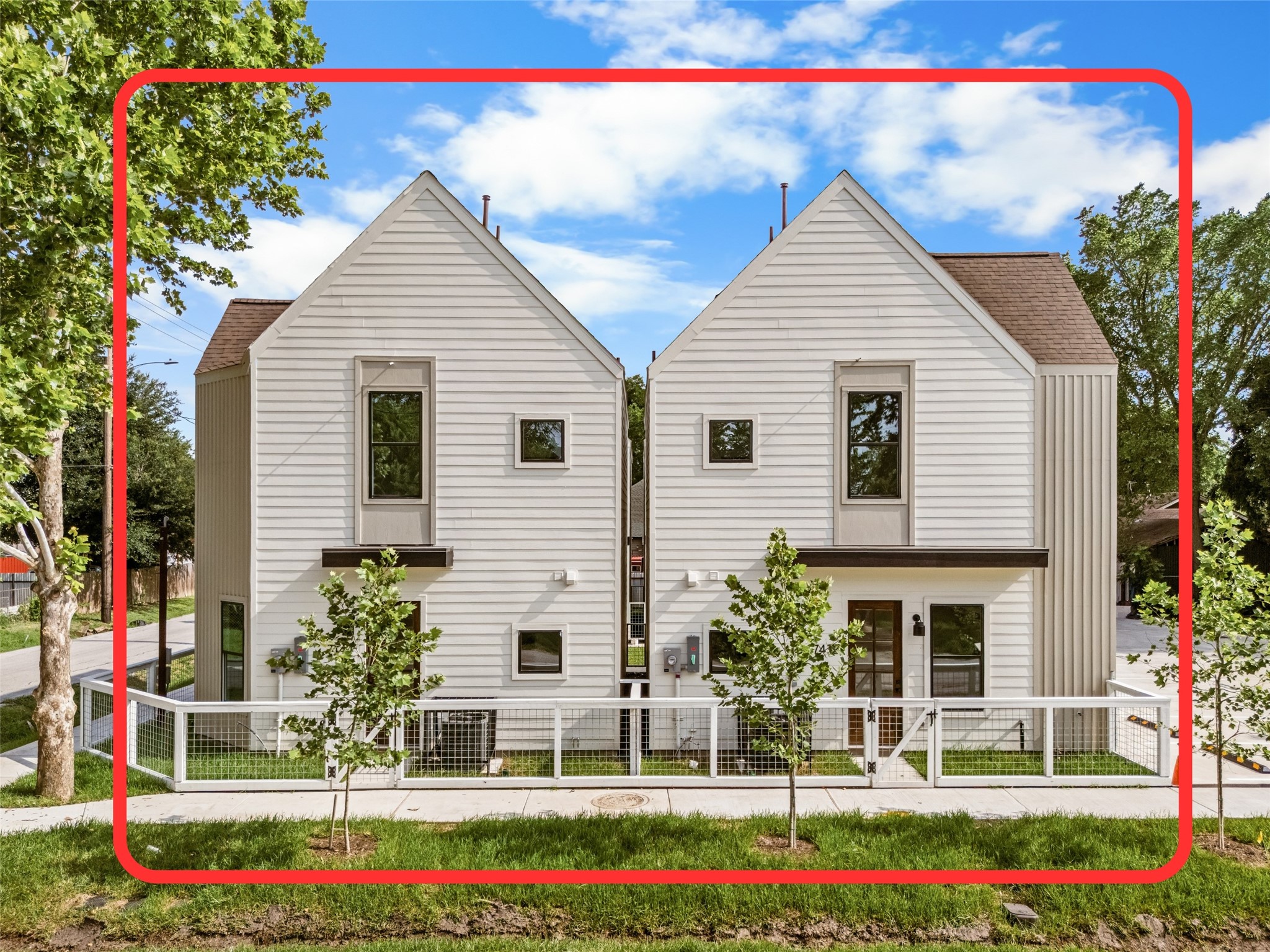 Perfectly symmetrical rear facades complete with young shade trees and neat fencing.