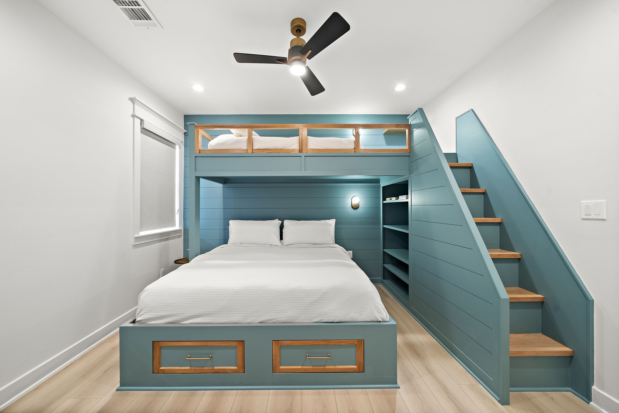 Secondary bedroom with built-in bunk beds, adjustable shelving, lighting and stairs to the top bunk. Kingsized on bottom and twin on top. Two drawers located at base of king sized bed.