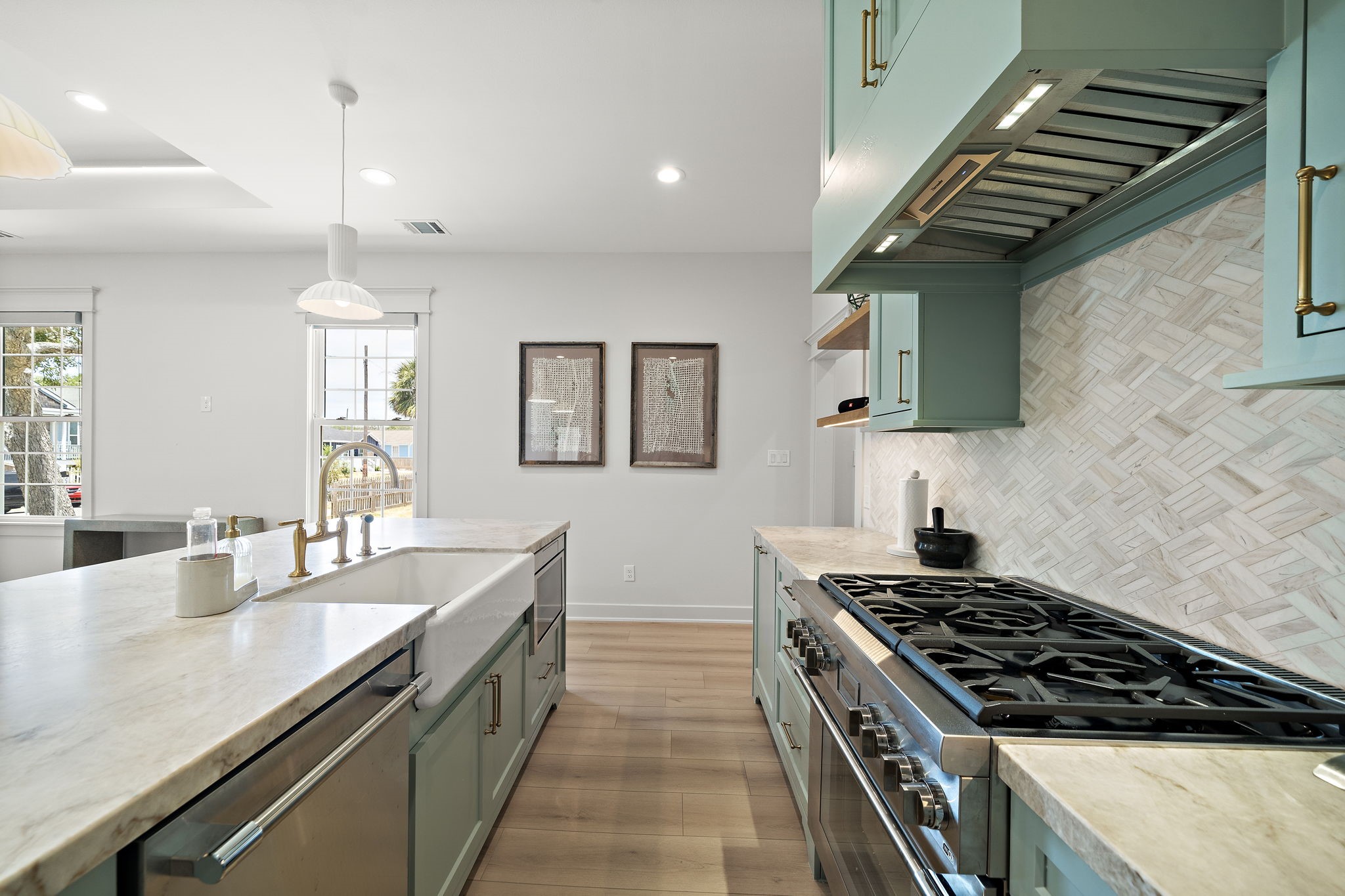 View of kitchen island, stainless steel appliances, gas stove and tons of countertop space.