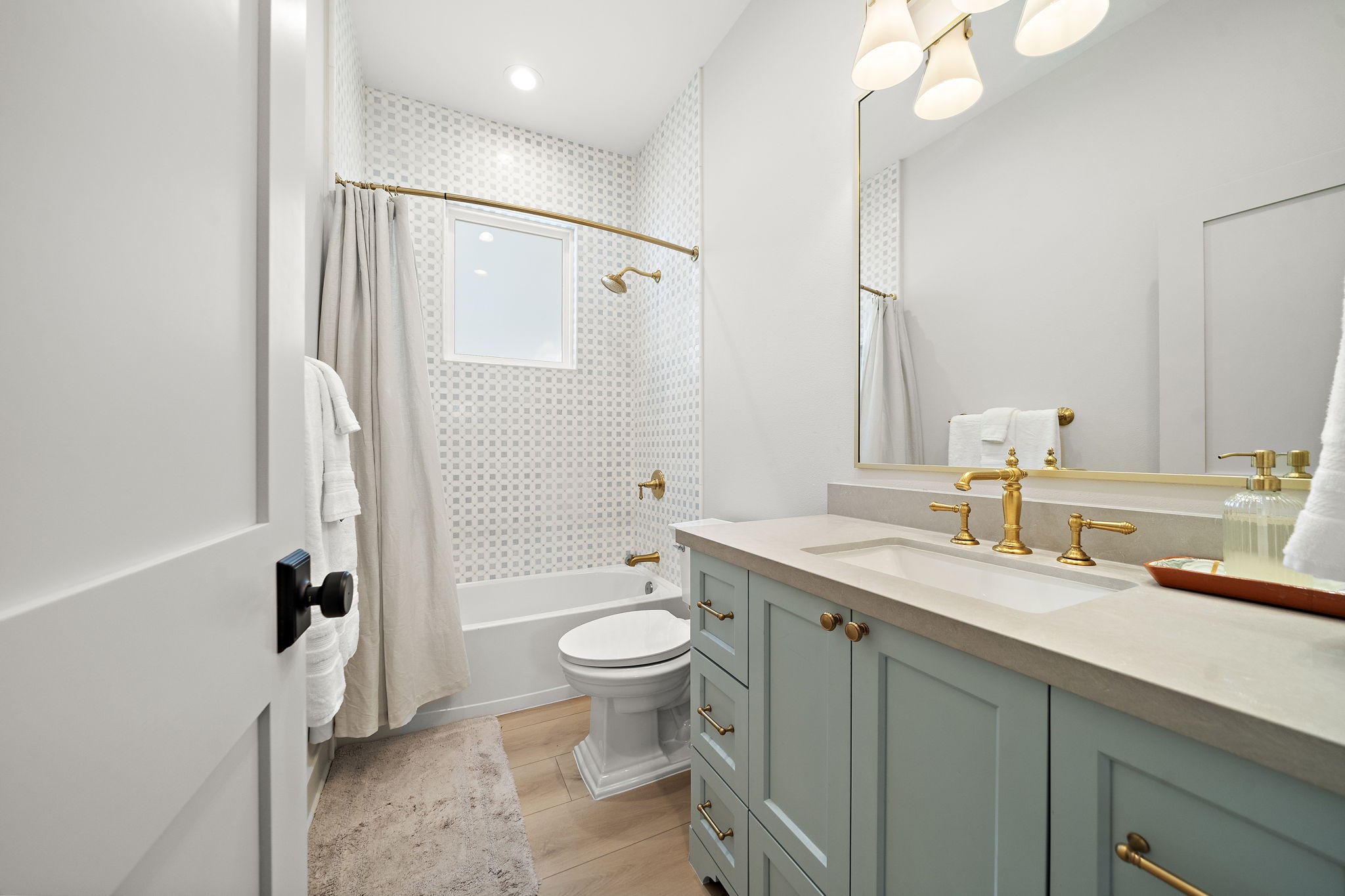 First bathroom at the front of the home with a tub/shower combo, Kohler finishes, and cabinets & drawers providing plenty of storage space.