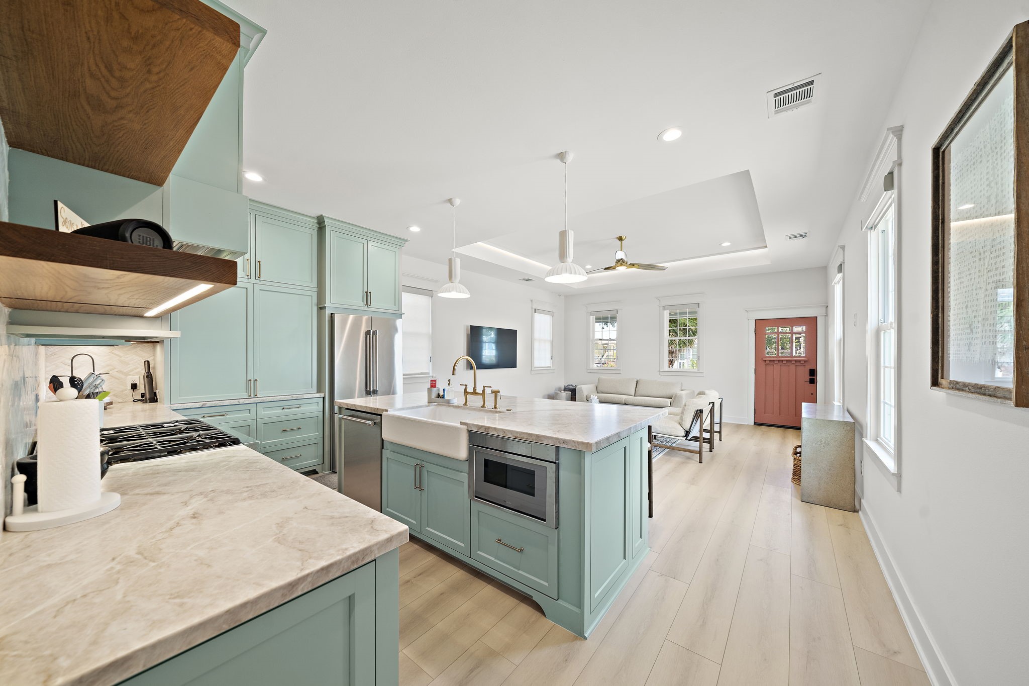 Kitchen has Thermodor gas double oven, under mount microwave, dishwasher, and fridge. Custom coffee bar is located behind large cabinet doors.