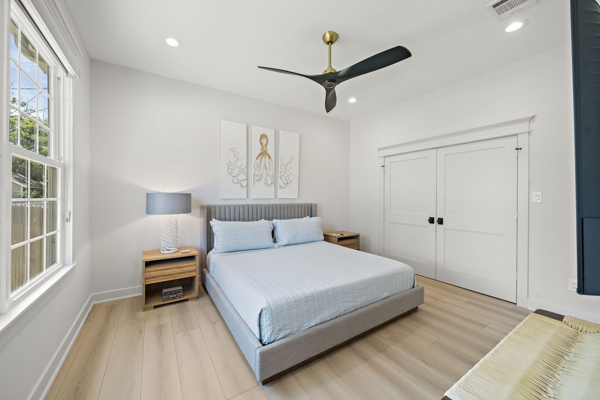 Primary bedroom with recessed lighting, Miele ceiling fan, closet with built-ins, custom black out shades, and ensuite bathroom with shower.