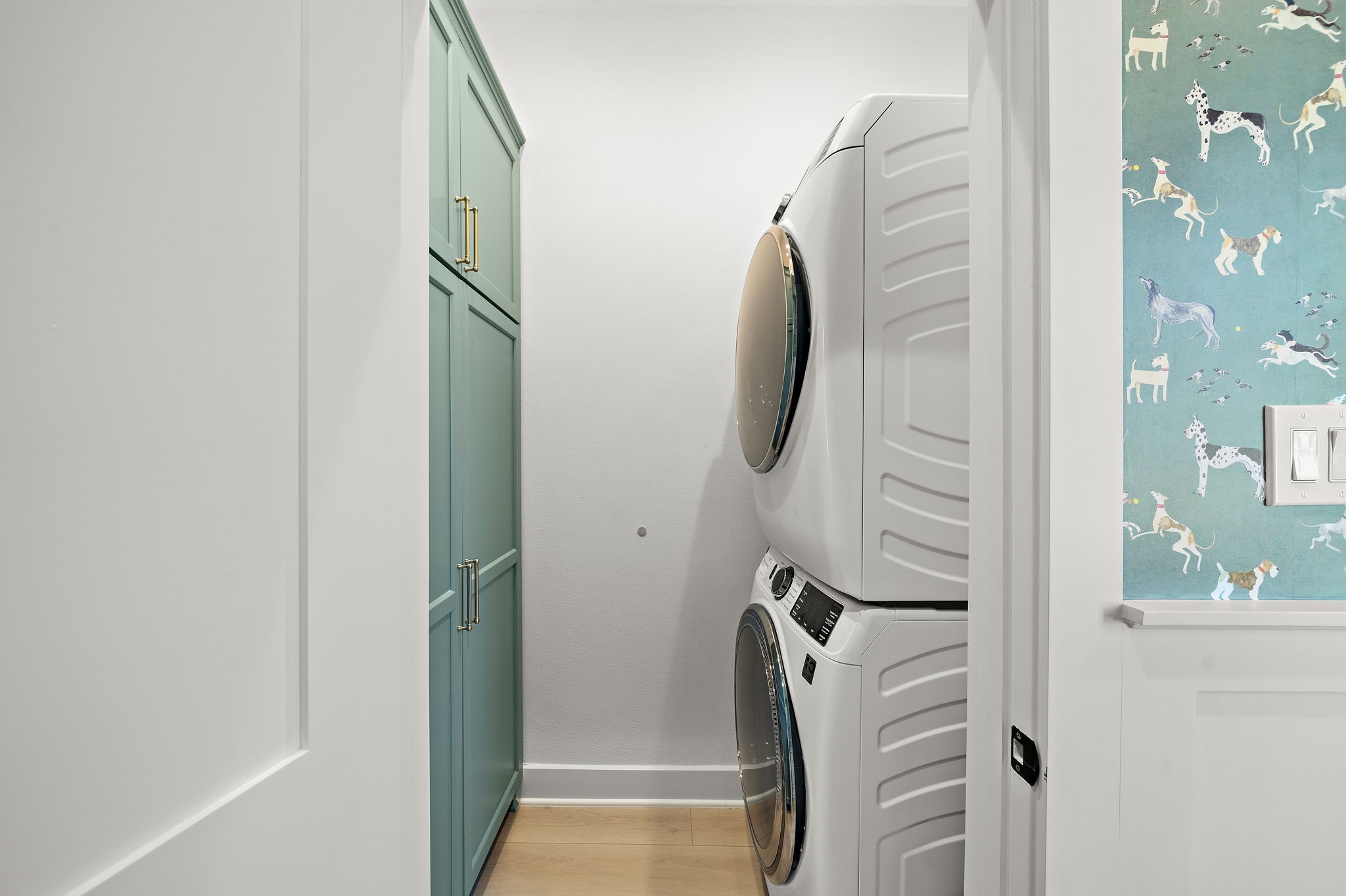Utility room with full size washer/dryer and built-in cabinets for storage. No detail was left behind - outlet for vacuum located behind cabinet door.