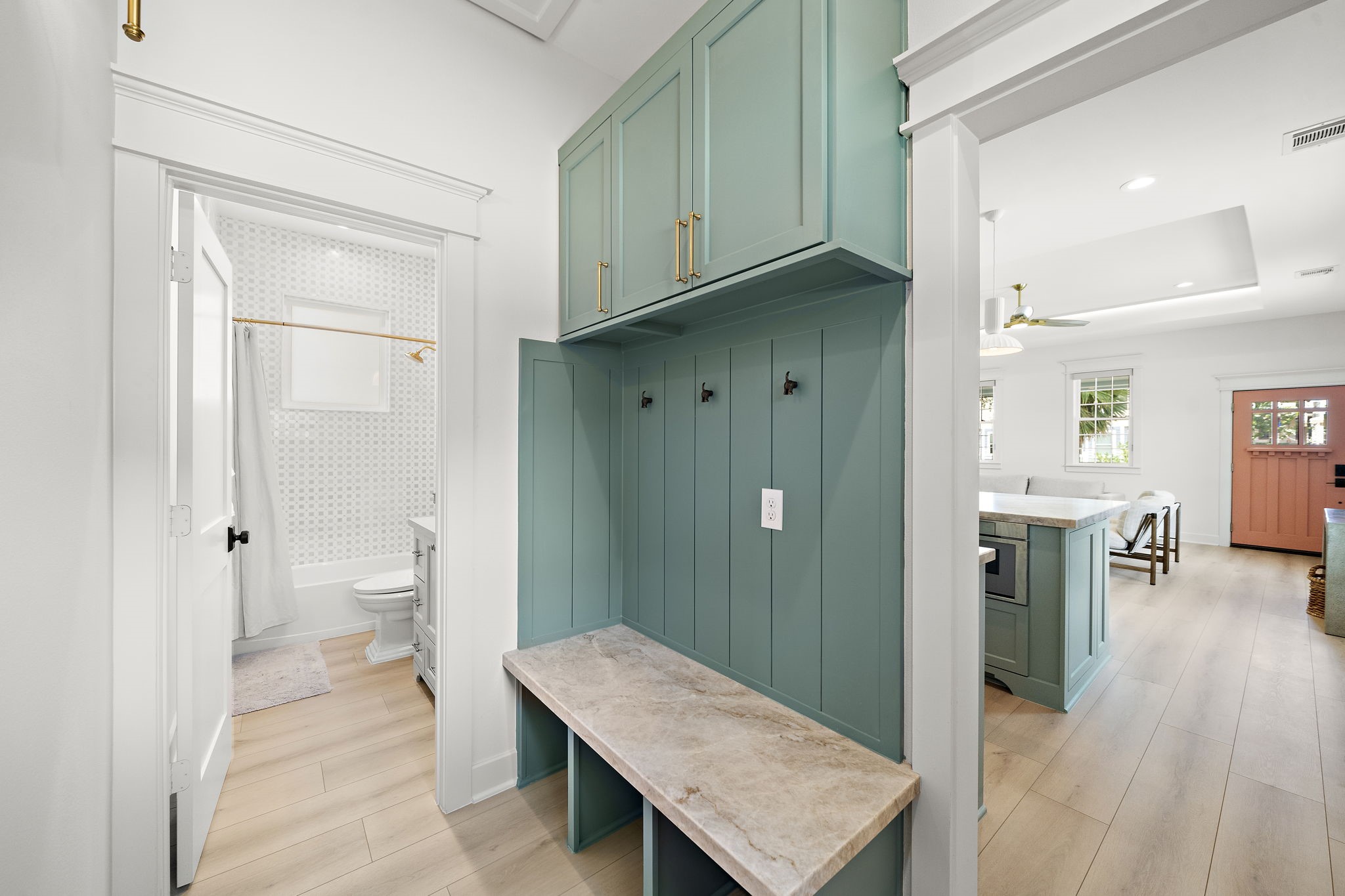 Custom mudroom off the kitchen featuring built-in cabinets, hooks and cubbies for storage. First bathroom is to the left.