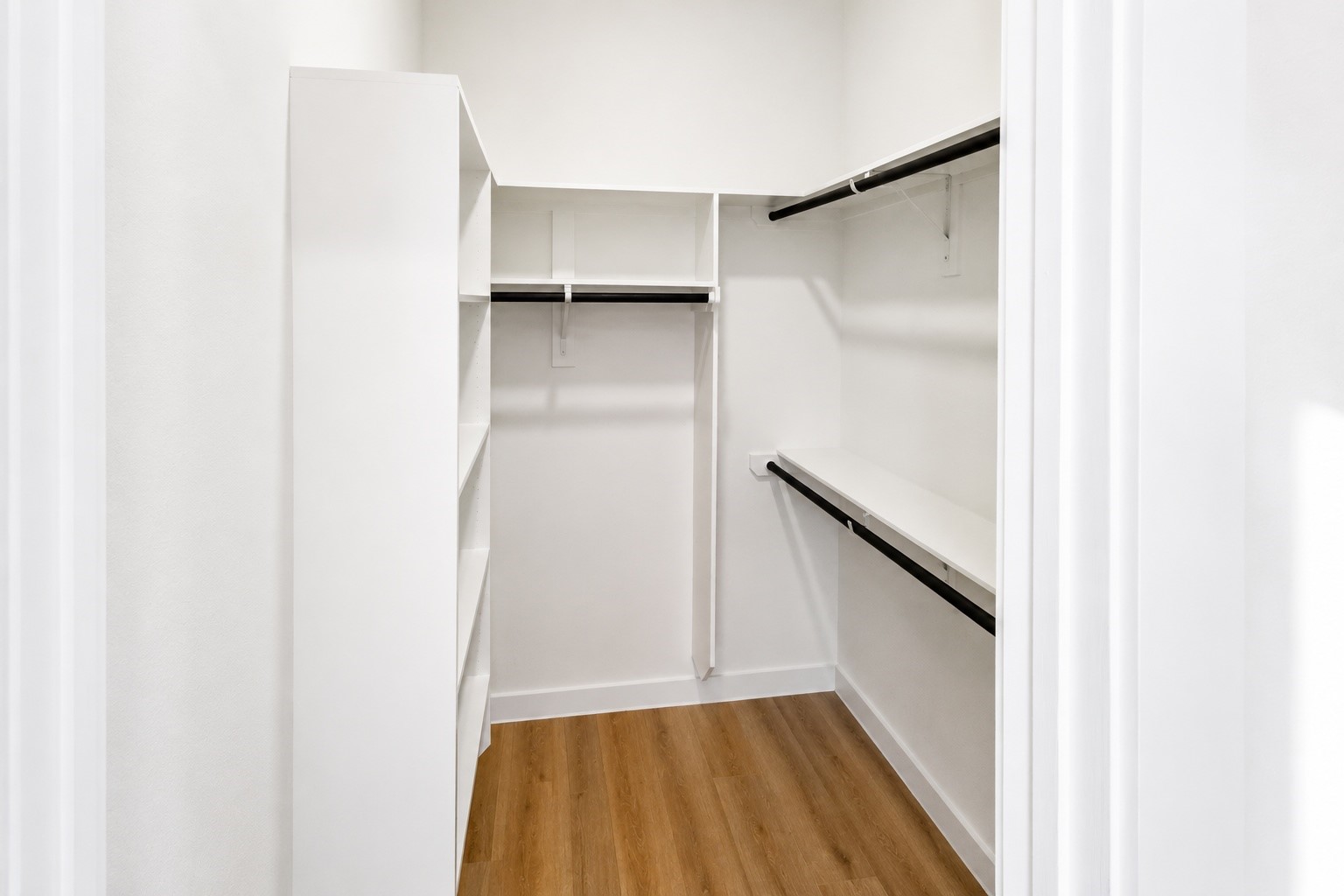 Well appointed walk in closet offers custom built shelving, multiple hanging sections, and generous storage for clothing, shoes, and accessories. Thoughtful organization maximizes every inch while keeping the primary suite clean, functional, and beautifully uncluttered