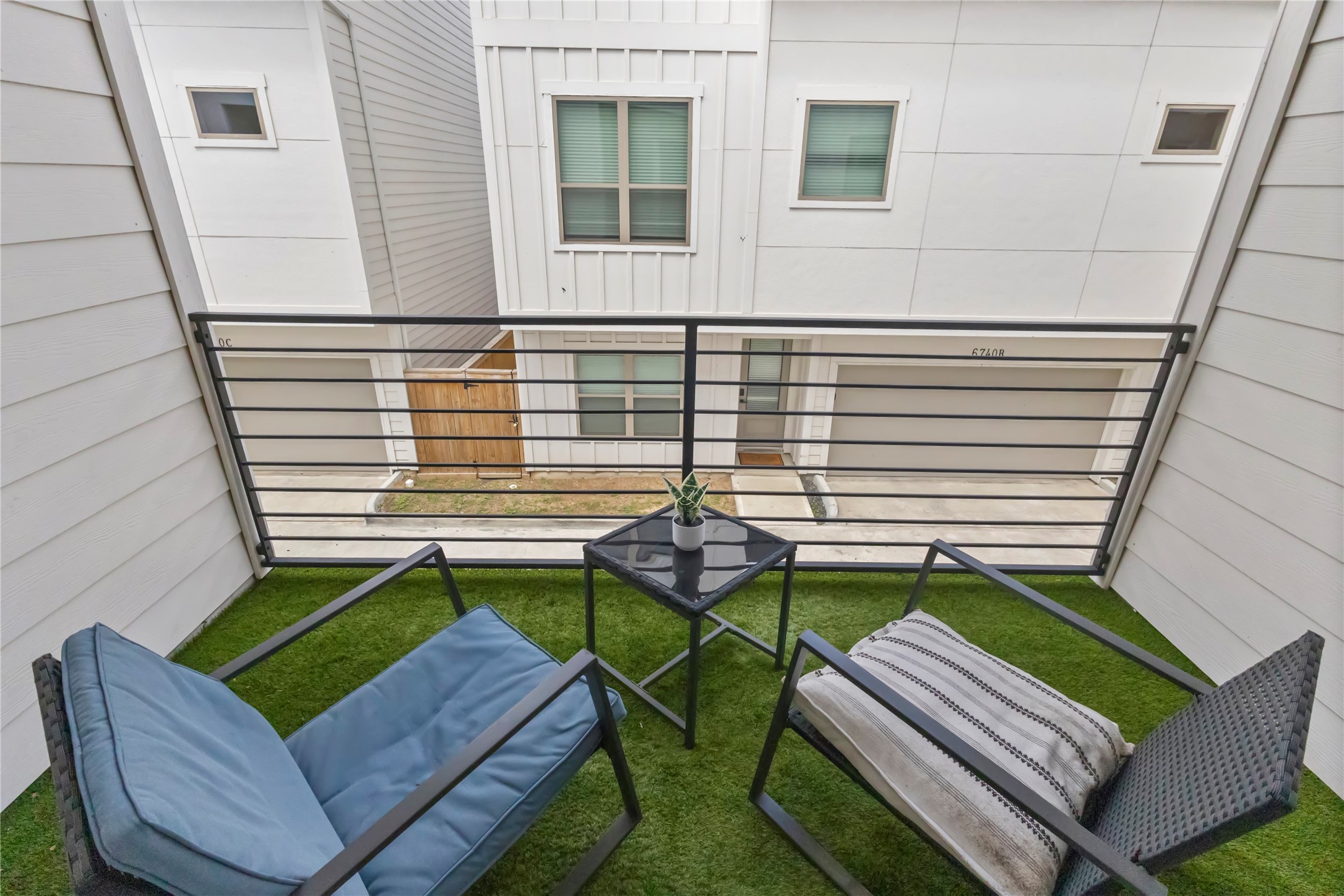 Step outside to a covered private balcony with space for morning coffee or an evening unwind. Low maintenance turf flooring and sleek metal railings create a comfortable outdoor retreat just off the main living area.