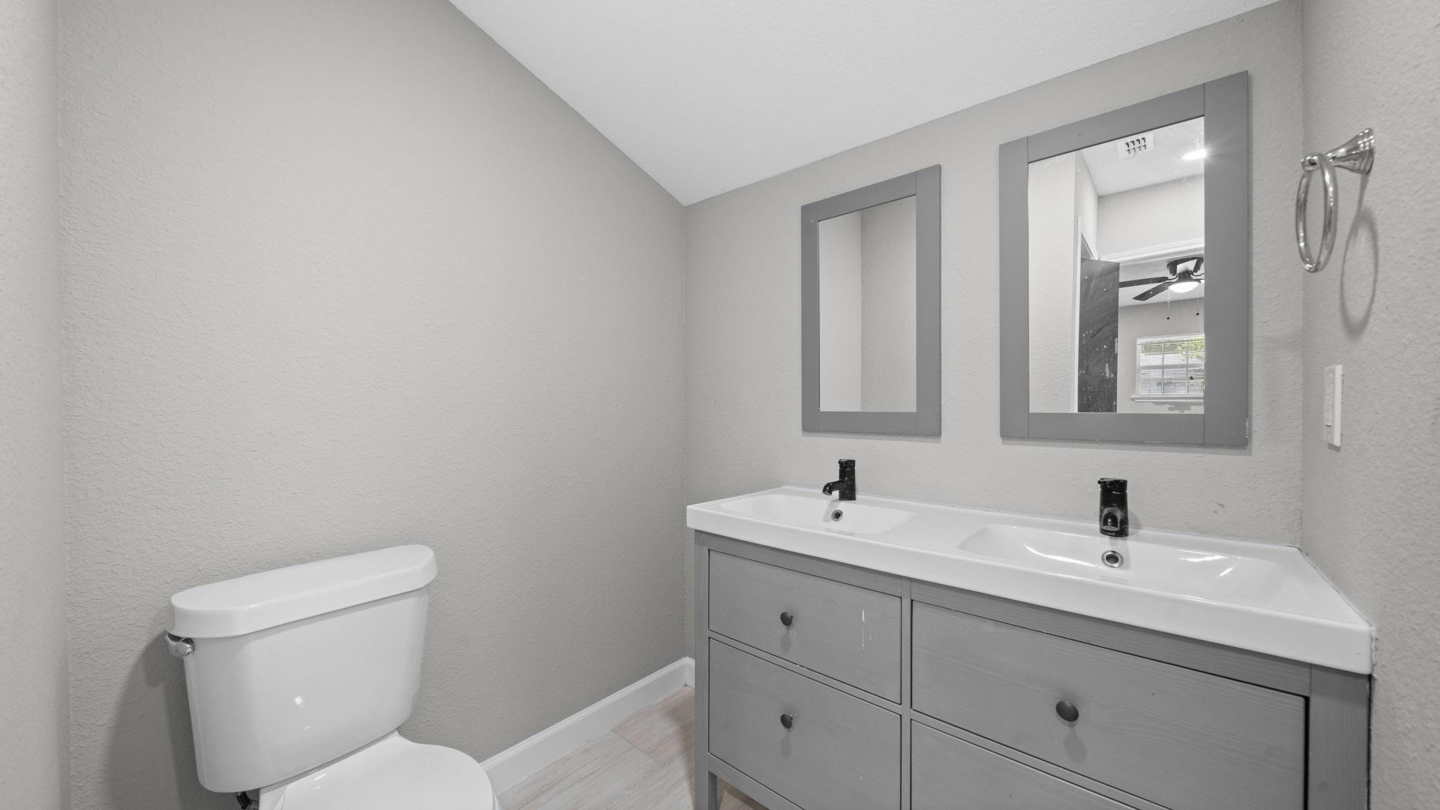 The primary bath features tile flooring and a conveniently located closet, offering additional storage and organization while complementing the suites comfort and functionality.