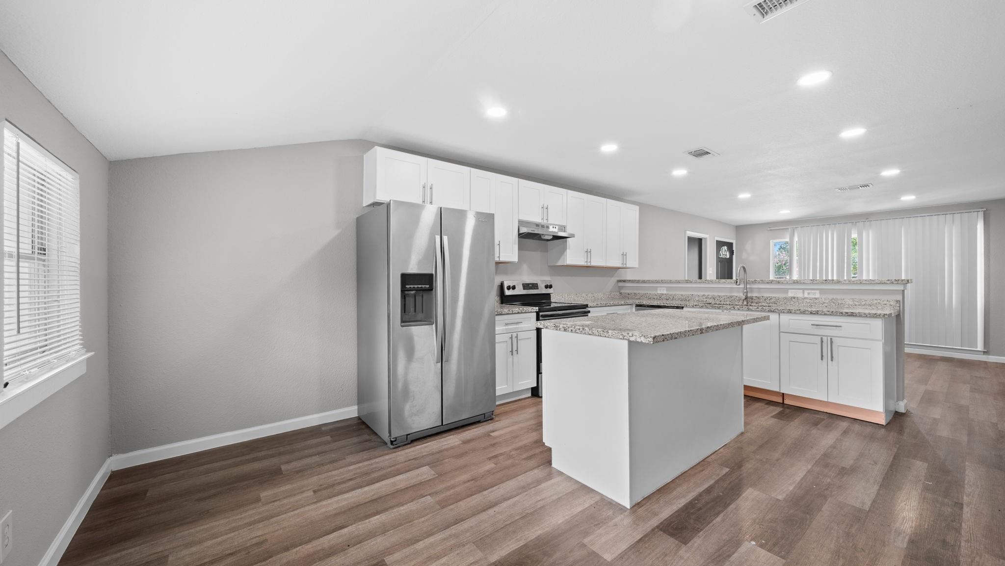 The center island offers inviting bar seating, creating a natural gathering place where casual dining, conversation, and culinary creativity come together in a beautifully connected kitchen.