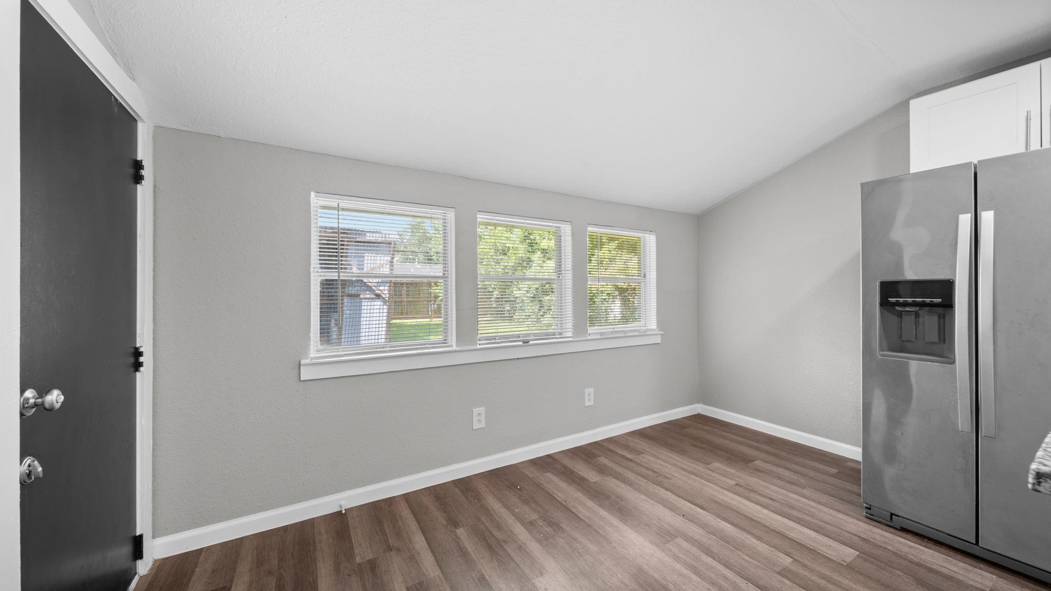 Bathed in natural light from three generously sized windows, the breakfast area offers a bright, welcoming setting for morning coffee or casual dining. Luxury vinyl flooring adds a sophisticated finishing touch, combining timeless appeal with lasting durability and easy maintenance.