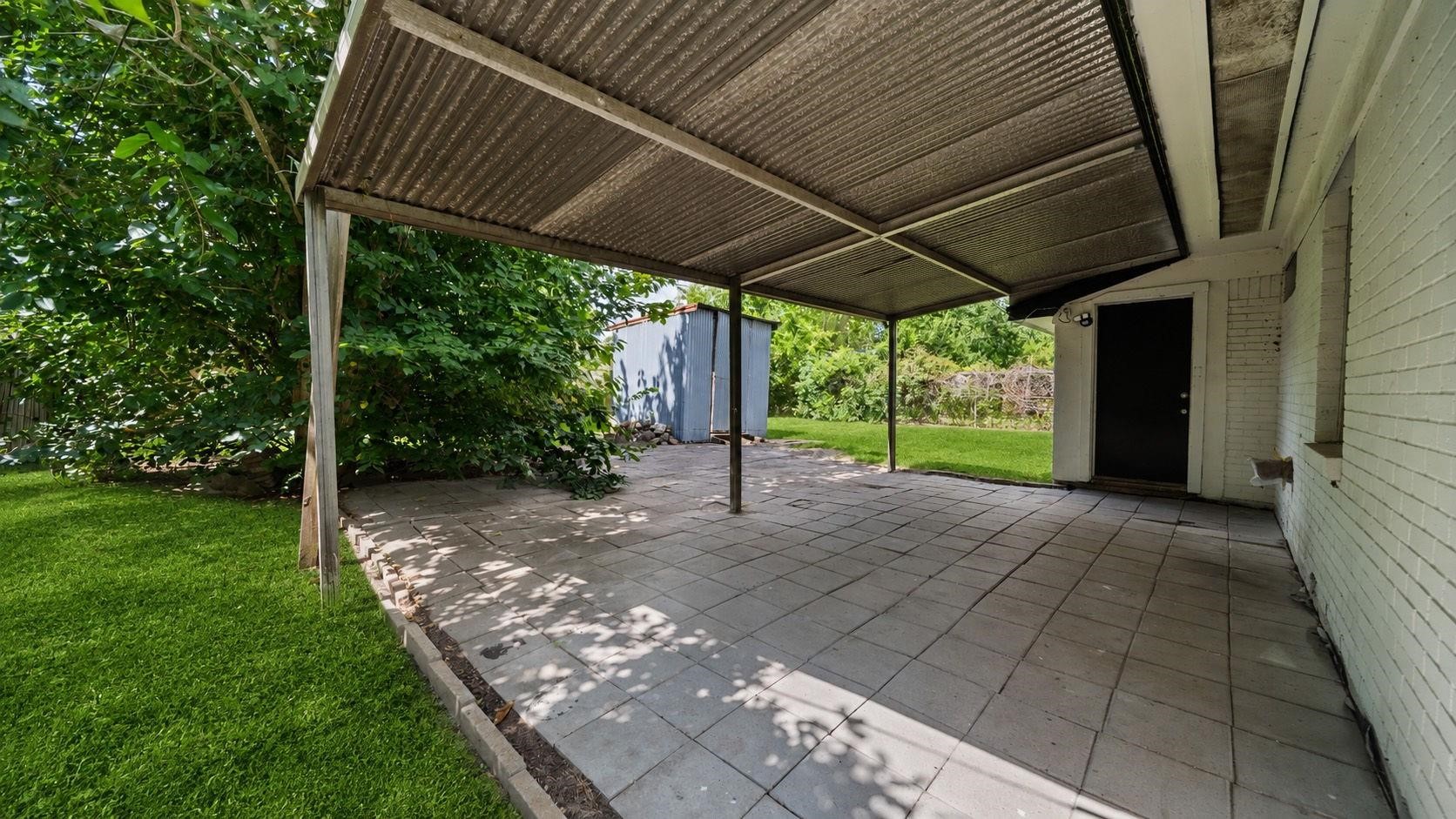 The covered back patio, finished with attractive concrete tile flooring, offers an inviting outdoor retreat for enjoying morning coffee, hosting weekend gatherings, or simply relaxing in the fresh air. Its sheltered design provides a comfortable extension of the home's living space, perfect for year-round enjoyment.