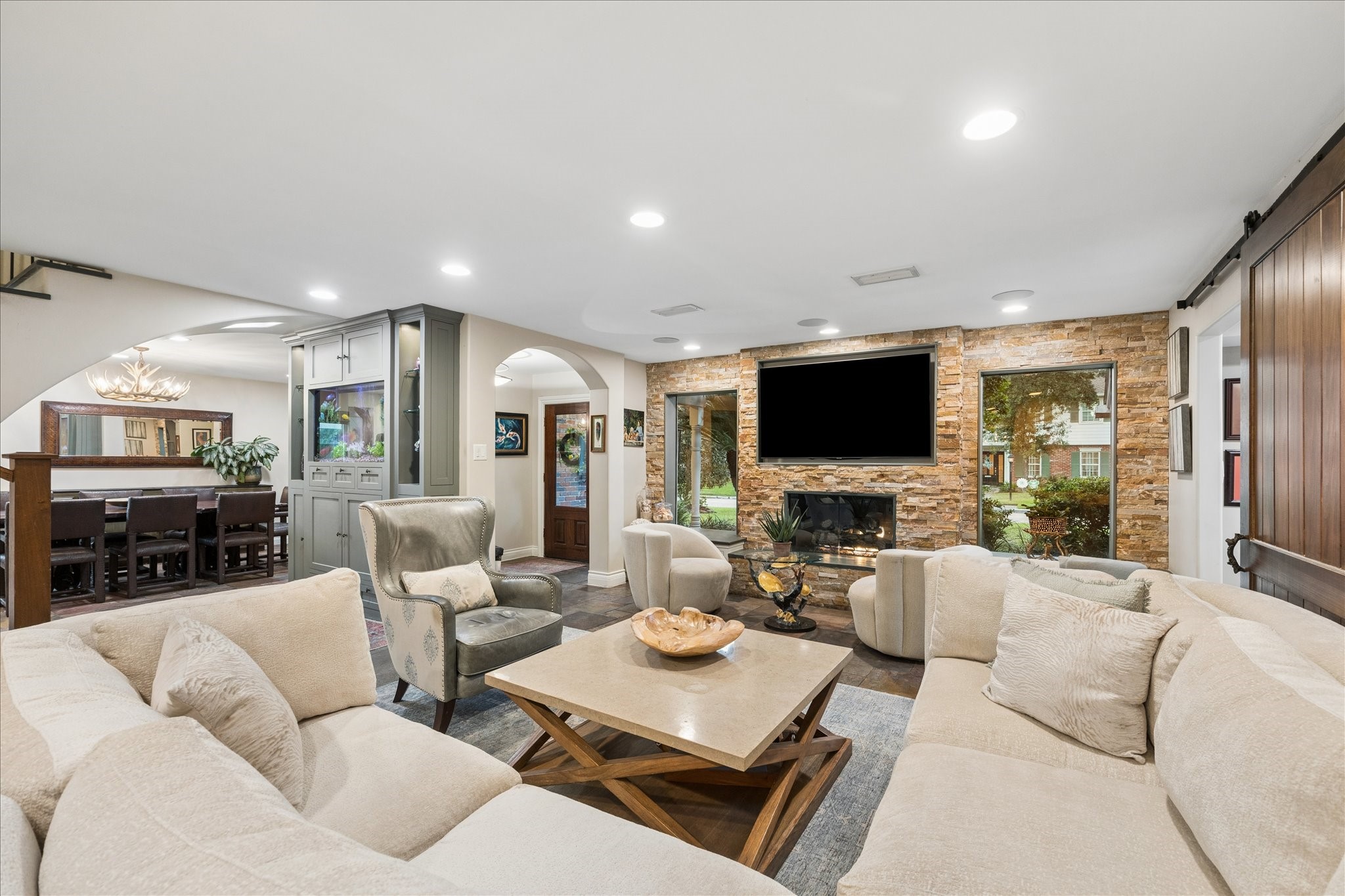Great room with stone fireplace, loads of natural light and sight lines throughout the entertaining areas