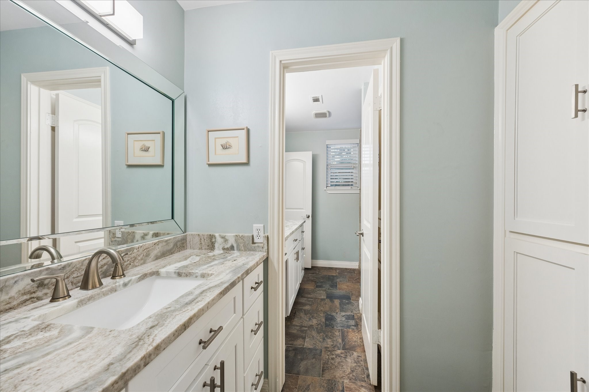 Upstairs bath is divided with sink and toilet in this space and just beyond the door is another sink and tub.