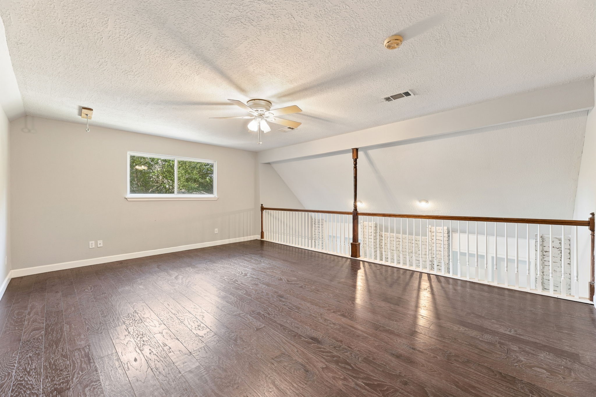 Open and airy upstairs game room with beautiful wood flooring!