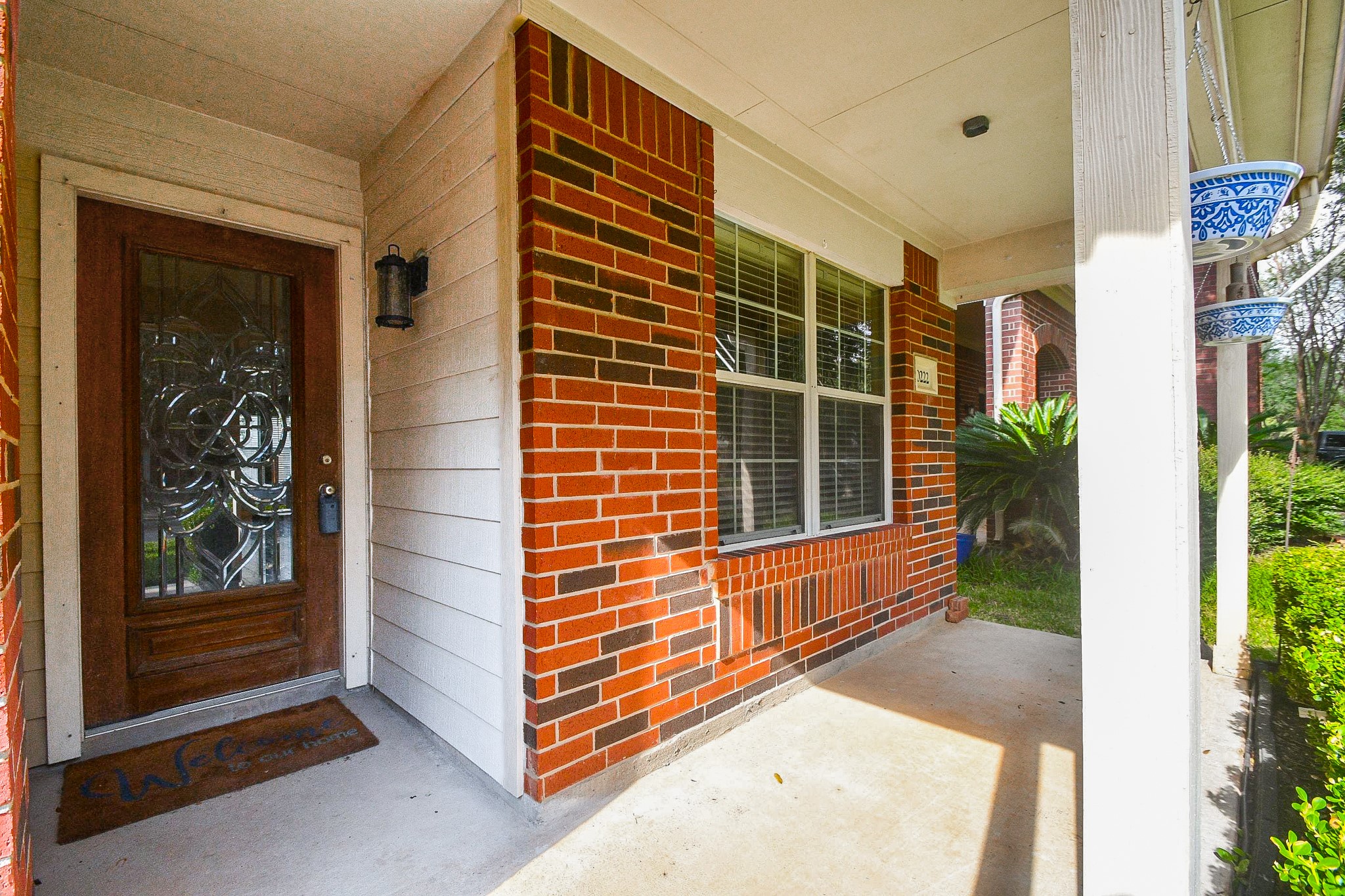 Charming brick front porch with an elegant glass-paneled door and cozy seating area, perfect for relaxing outdoors. Charming brick front porch with an elegant glass-paneled door and cozy seating area, perfect for relaxing outdoors.