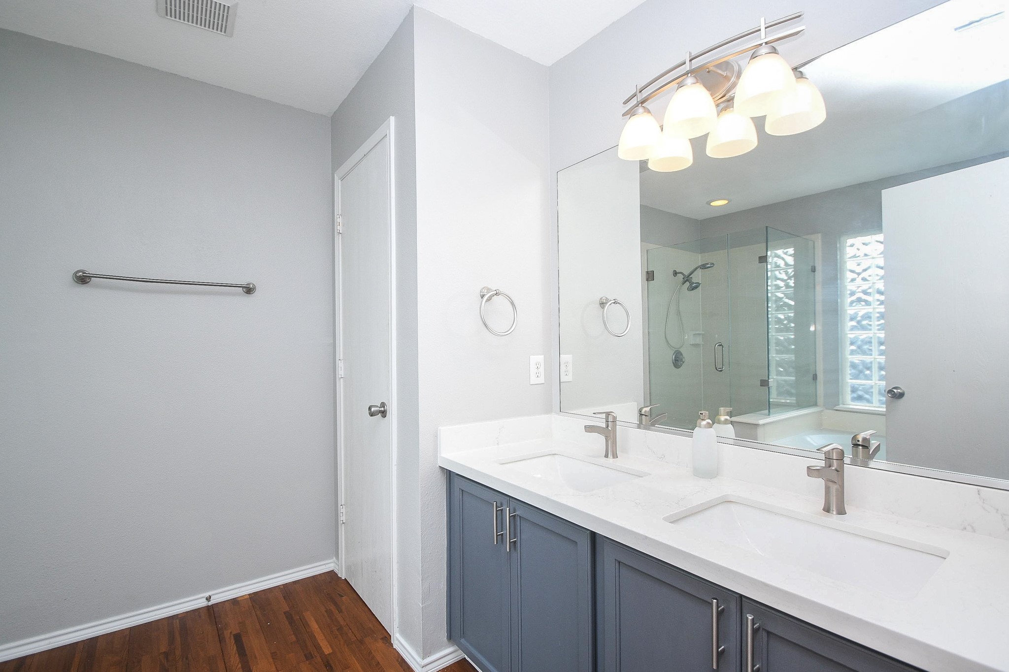 Modern bathroom with a dual-sink vanity, sleek fixtures, and a spacious glass-enclosed shower.