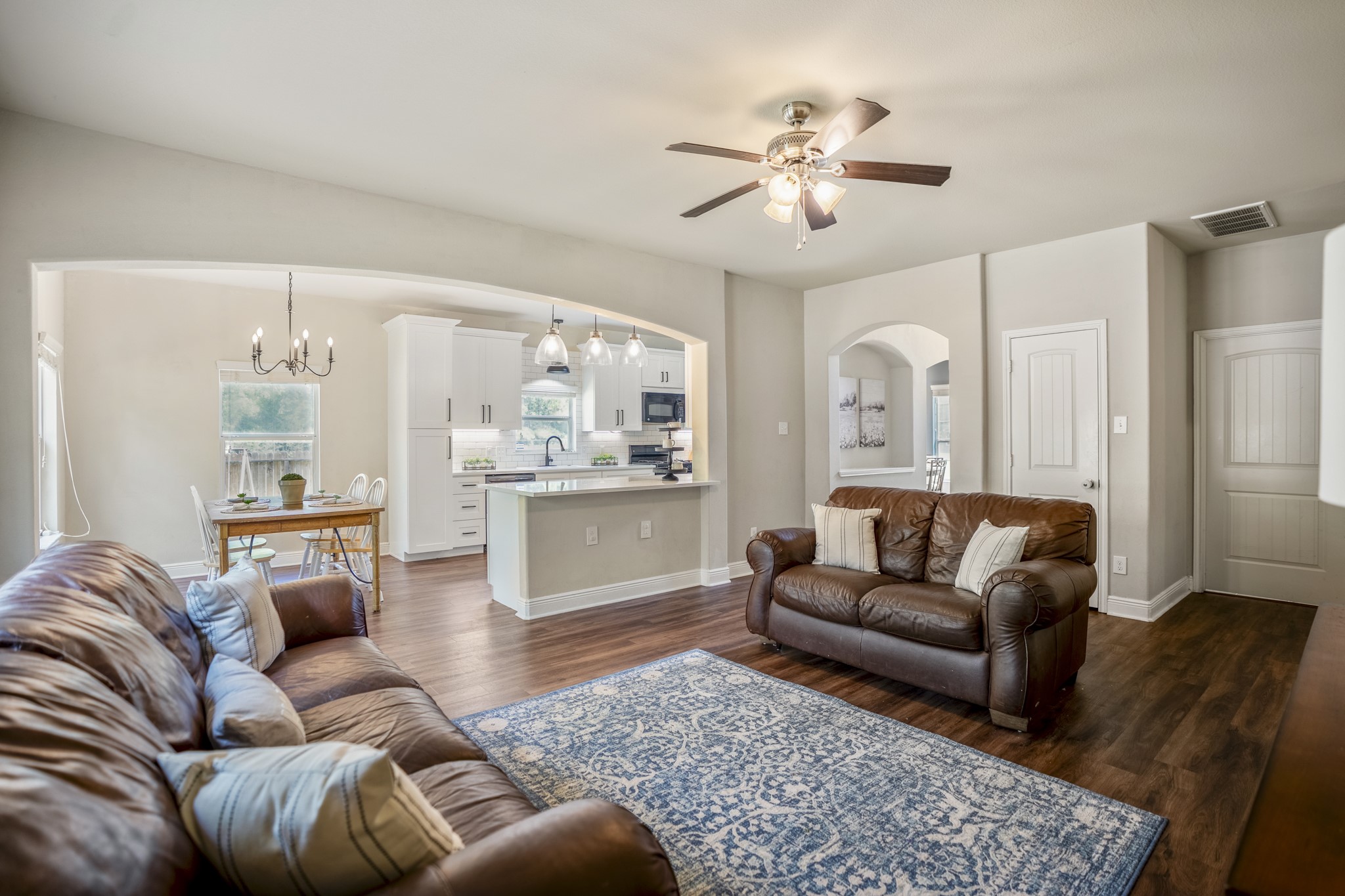Looking back across the living room, you can see how closely it connects to the kitchen and breakfast area beyond. The room still has plenty of definition for a full seating arrangement, while the open connection keeps conversation moving easily between the main gathering spaces.