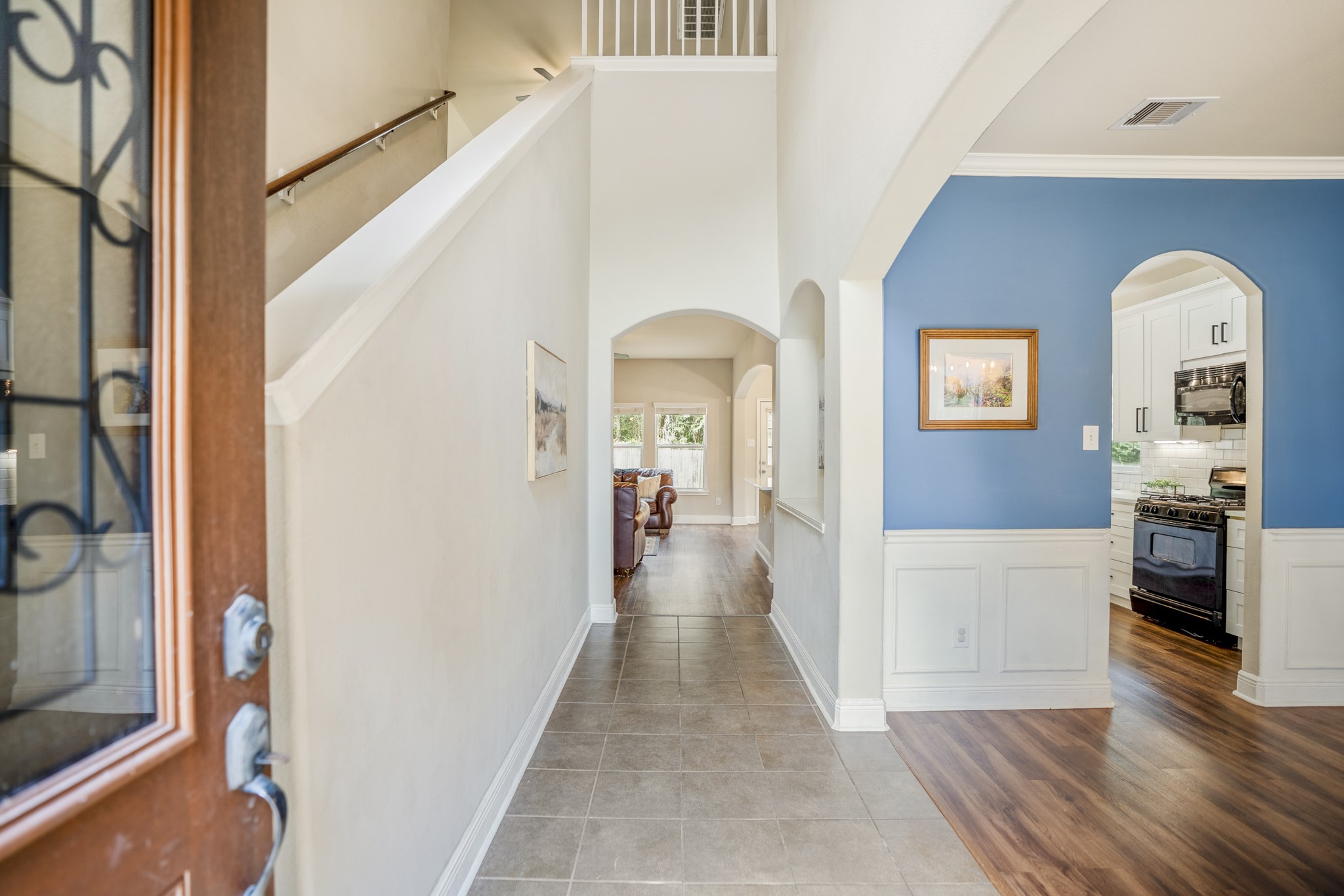 Step inside to a bright entry with the staircase immediately to the left and the formal dining room opening to the right. The upper bannister gives you a glimpse of the second floor, while the hallway ahead leads deeper into the home toward the kitchen, breakfast area, and living room.