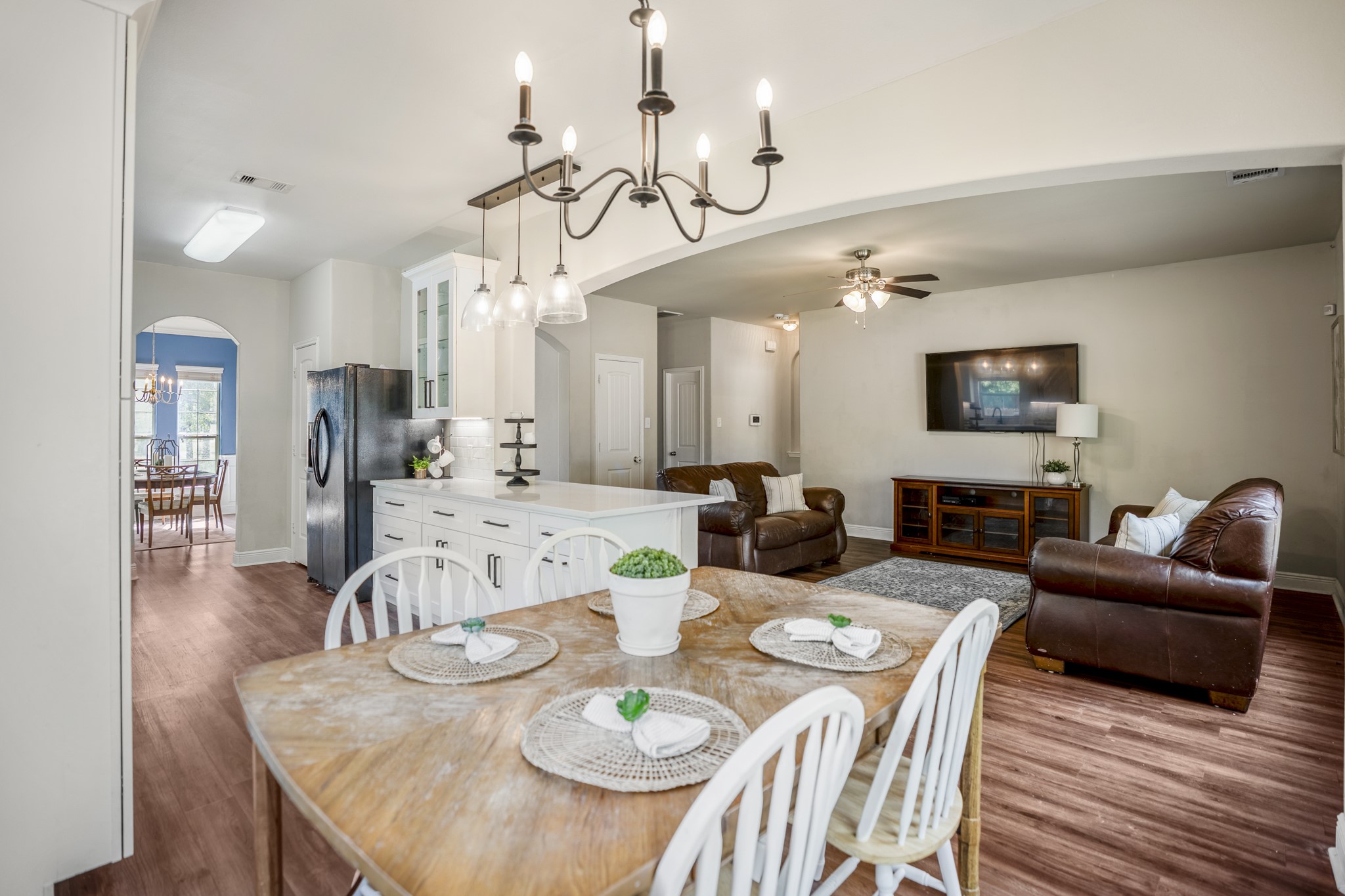 This view really shows how the breakfast area, kitchen, and living room work together. The breakfast bar keeps the kitchen open to the surrounding spaces, so whoevers cooking can still stay part of the conversation while the living room sits just beyond.