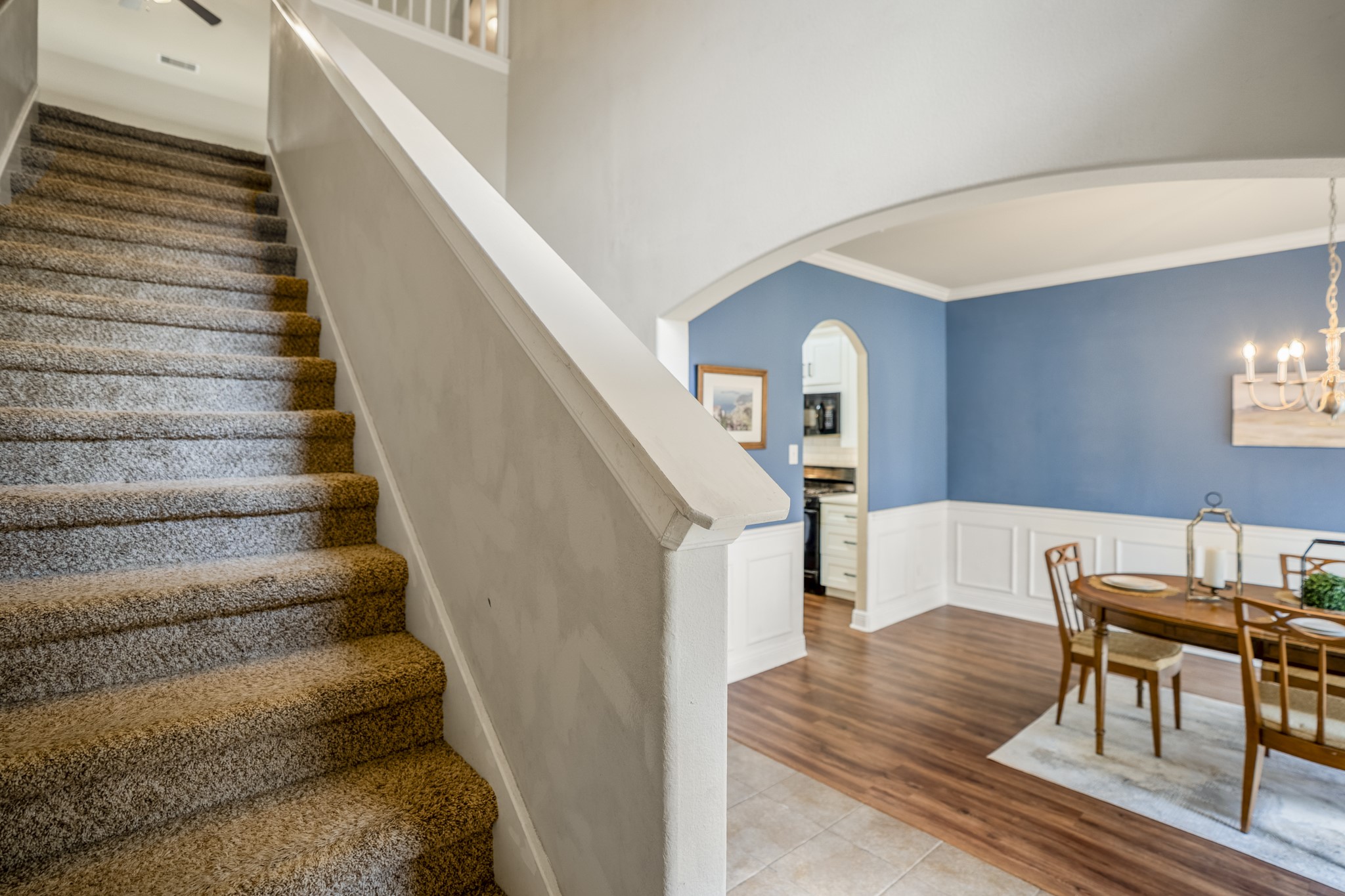 As you head upstairs, the open stairwell gives you a glimpse of the second floor above while keeping the formal dining room in view below. Its a nice visual connection between the two levels, with the blue-and-white dining room adding a pop of personality before the staircase leads you toward the gameroom and secondary bedrooms.