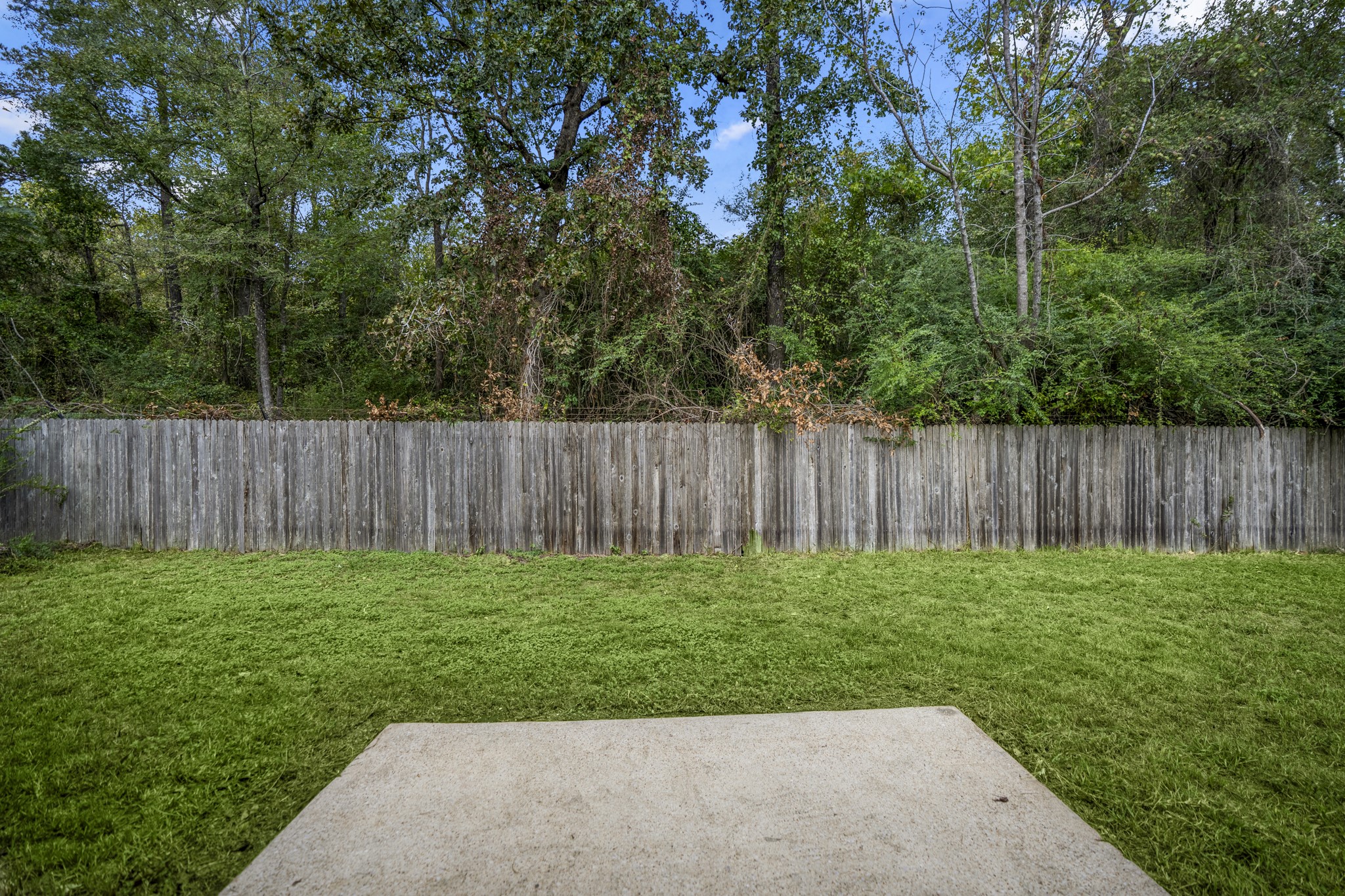 Step outside to a backyard that feels especially open thanks to the homes setting, with no back neighbor and mature trees lining the view beyond the fence. The patio gives you an easy spot for grilling, outdoor dinners, or a quiet morning coffee, while the lawn leaves plenty of room to enjoy the yard without feeling boxed in.