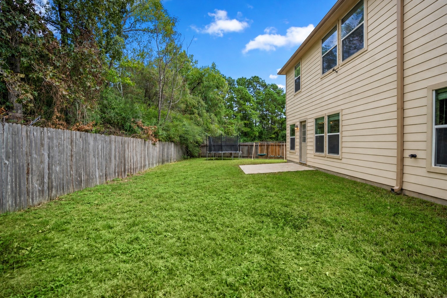 Stepping back from the patio, you get a better sense of how much lawn stretches behind the home. The open space gives the backyard room to grow with future outdoor seating, play space, or landscaping, while the no-back-neighbor setting keeps the view feeling more open.