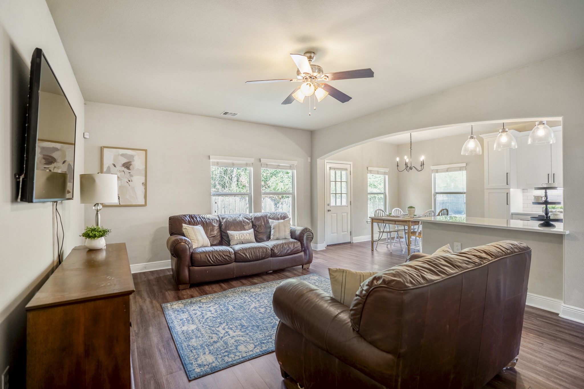 Moving into the living room, windows along the back and side bring in plenty of natural light and views toward the yard. Theres room to settle in for movie nights, slower weekends, or everyday downtime while still staying connected to the rest of the downstairs.