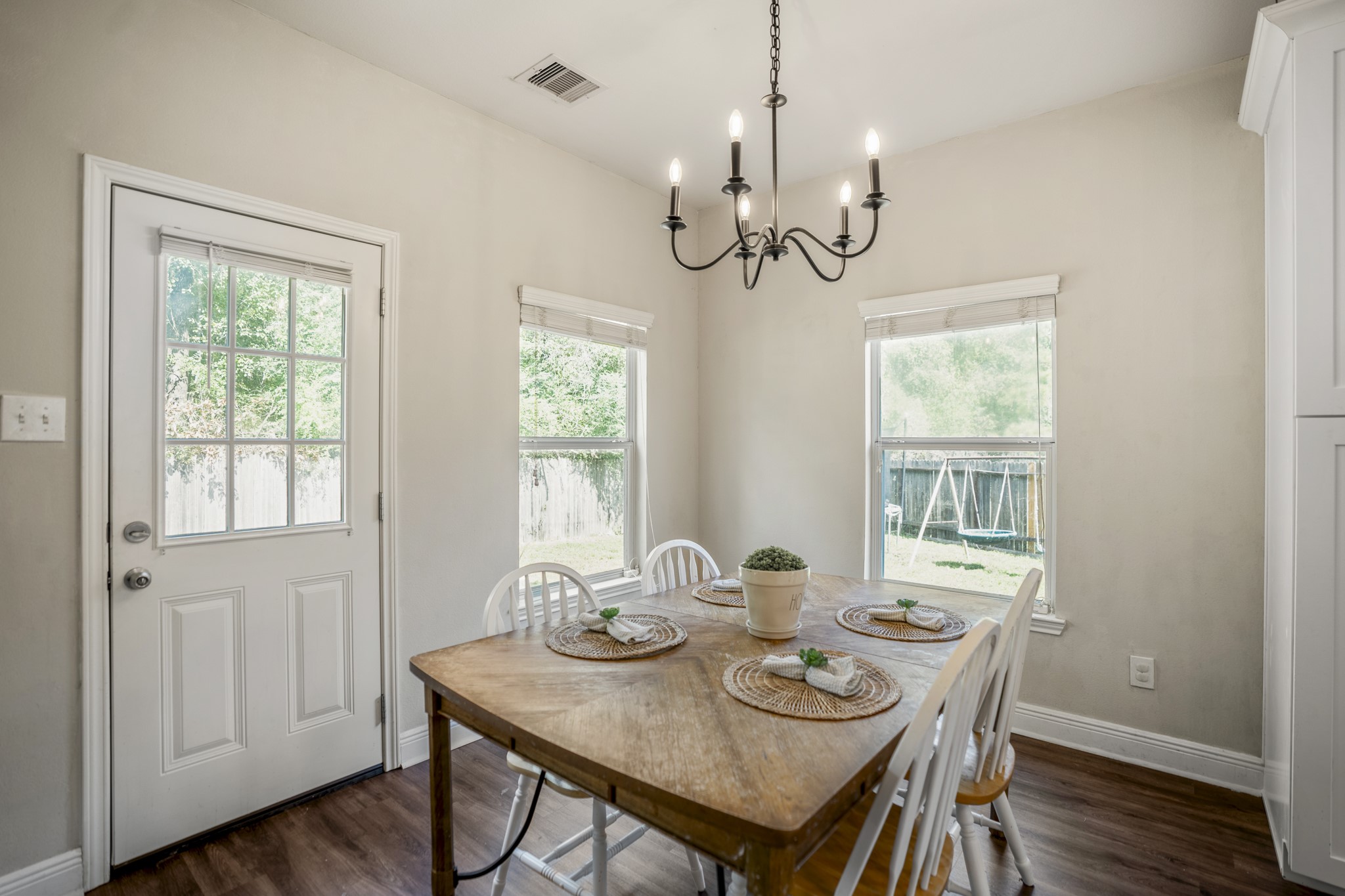 Finishing this section in the breakfast area, windows bring in natural light while the back door keeps the yard only a few steps away. Its an easy spot for morning coffee, casual dinners, or lingering at the table before heading outside.