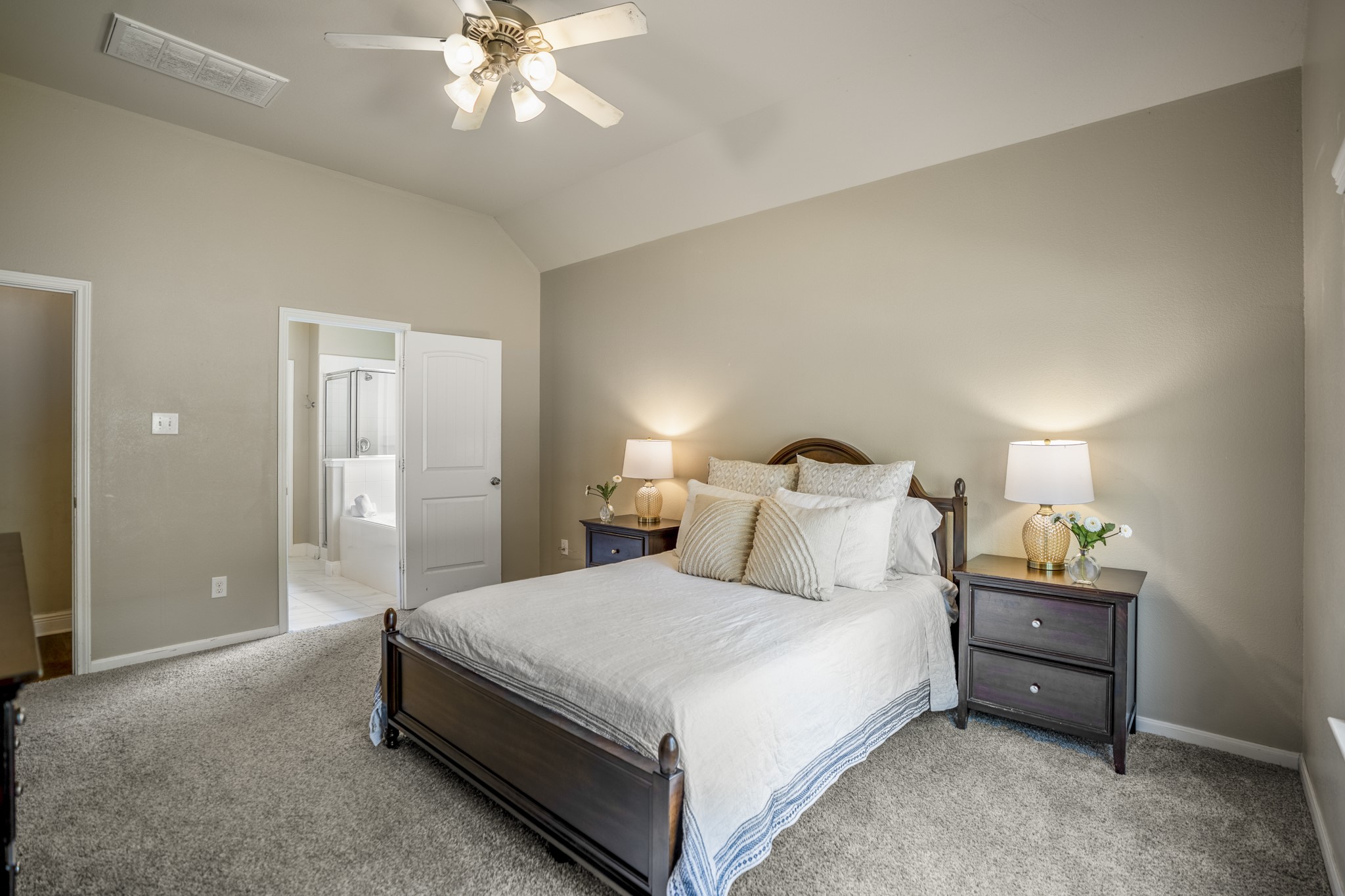 This angle gives you a better feel for the primary bedrooms size, with room for nightstands on both sides and extra furniture without crowding the space. The doorway on the left leads into the primary bath, keeping everything close at hand while the bedroom itself still feels calm and separate from the main living areas.