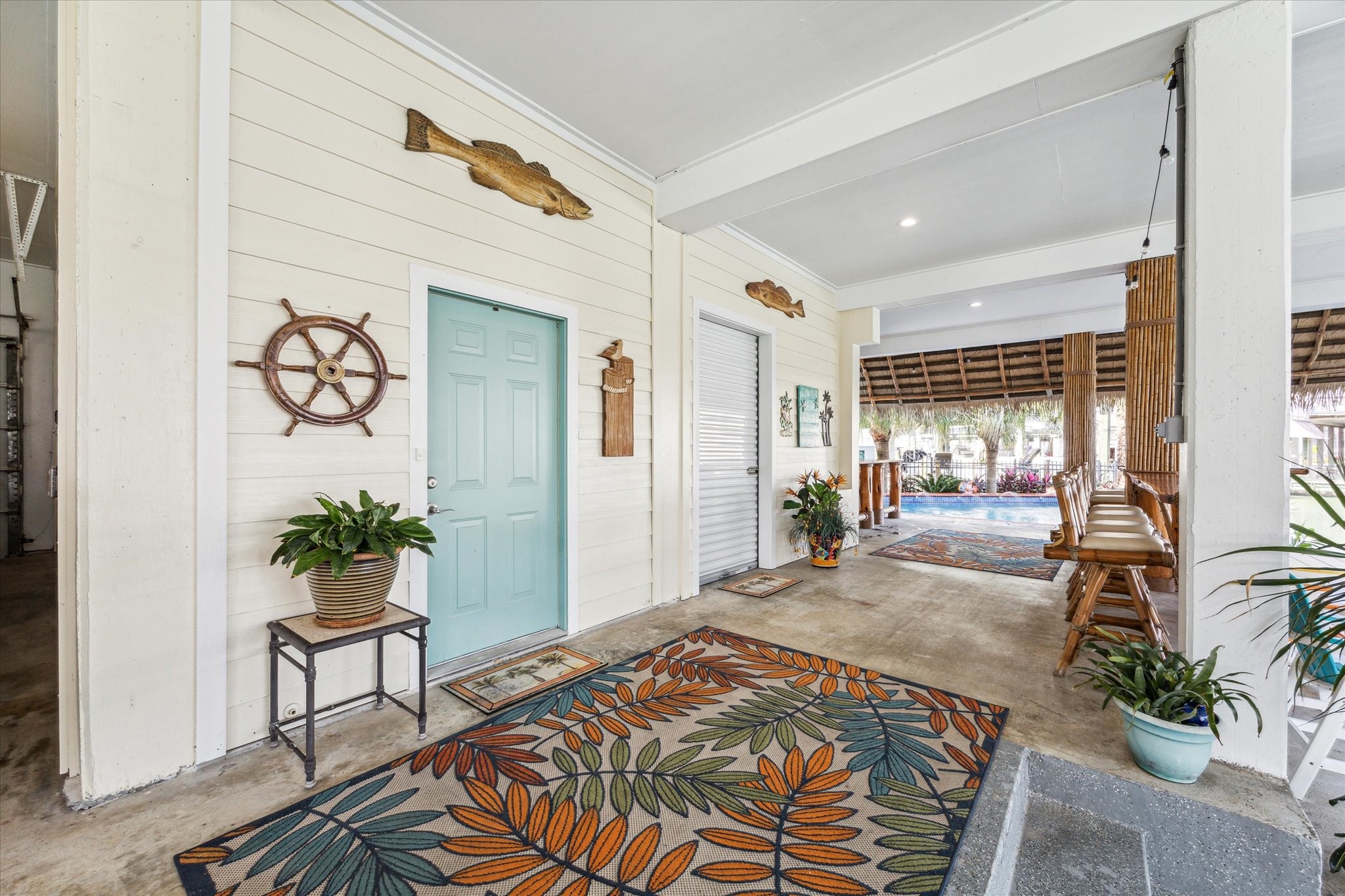 This garage level area provides an entrance into the home through the beautiful blue/green door or go through the roll up garage door to another garage space with a half bath. This patio space also has two tiki bars, access down to your 2 boat lifts or a place to sit under the palapa next to the pool. All of the bamboo has been refinished and the swivel bamboo barstool chars have been reupholstered.