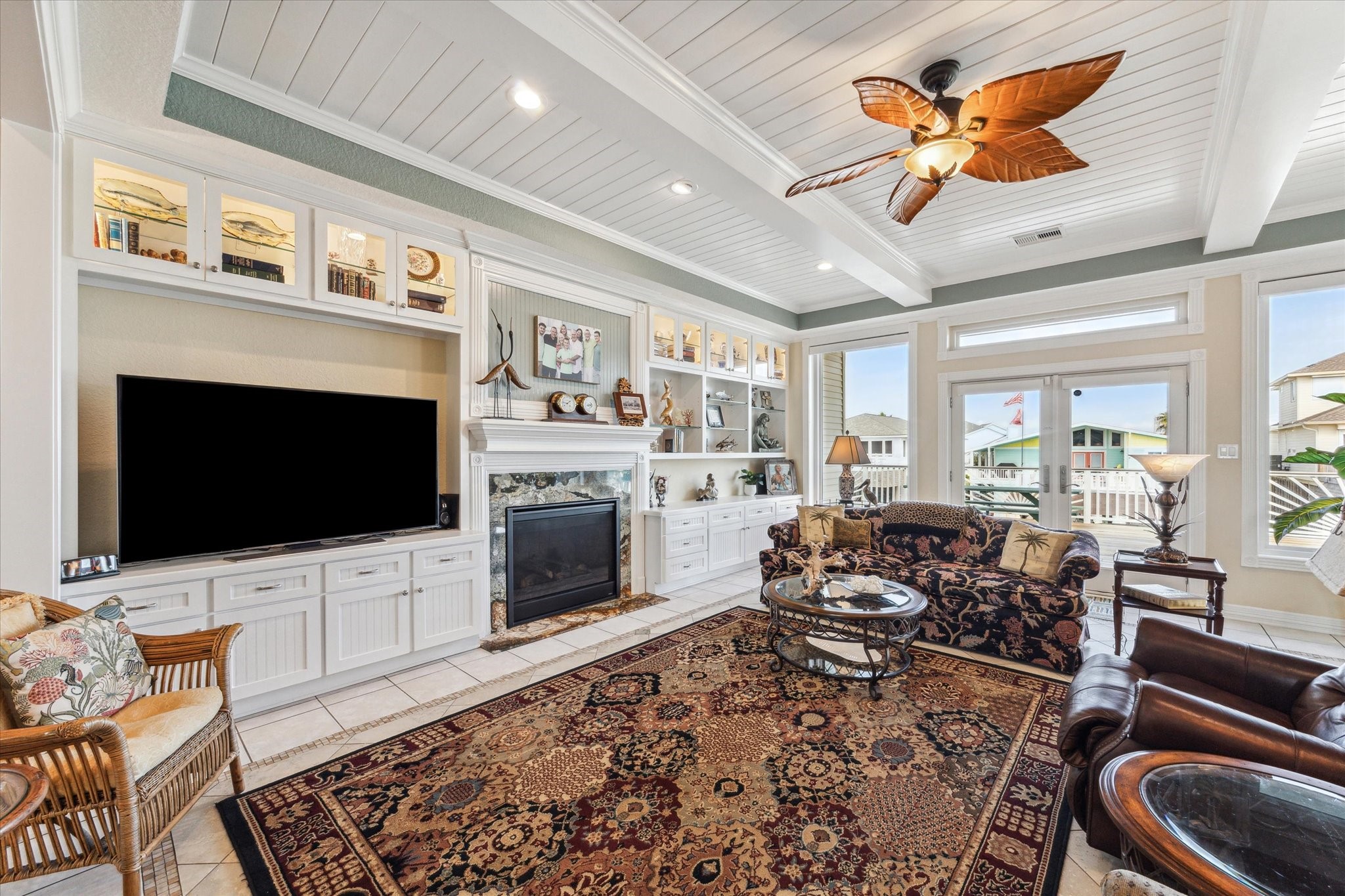 The beautiful custom cabinetry in the living room offers lighted glass door cabinets at the top and plenty of storage space below. The custom gas fireplace is highlighted with fluted trim & rosettes, a granite surround & mantle with beadboard accent wall.