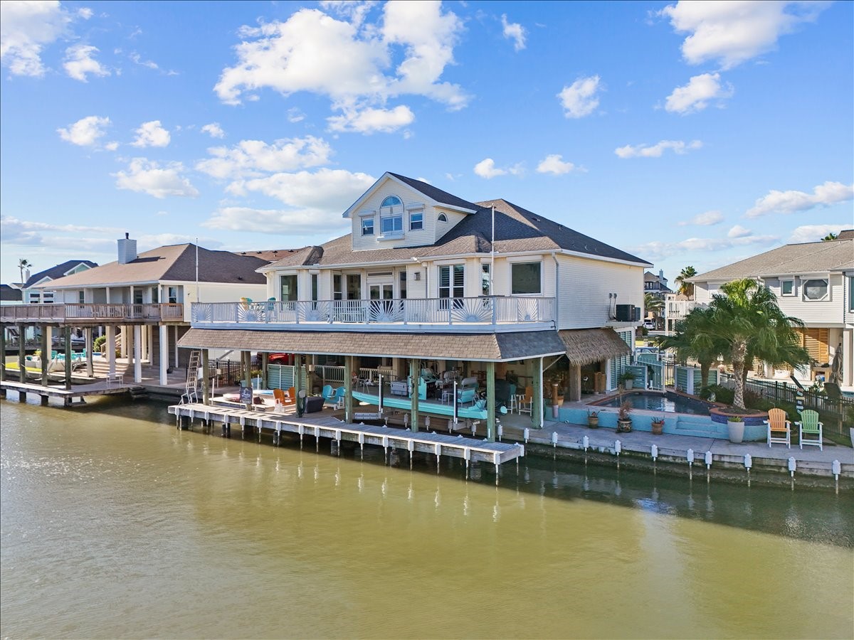 The expansive outdoor space at this home offers a raised heated pool surrounded palm trees and a covered synthetic palapa and tiki bar beside it as well as plenty of space in front of the pool to sit and enjoy the waterfront views. Below the second level deck that expands across the whole width of the home are two boat lifts (large cradle lift 33' by 10'3" and a platform lift 17' by 10'3" that can accommodate a boat lift or 2 jet skis) as well as a bait well, stainless counter space and sink & more!