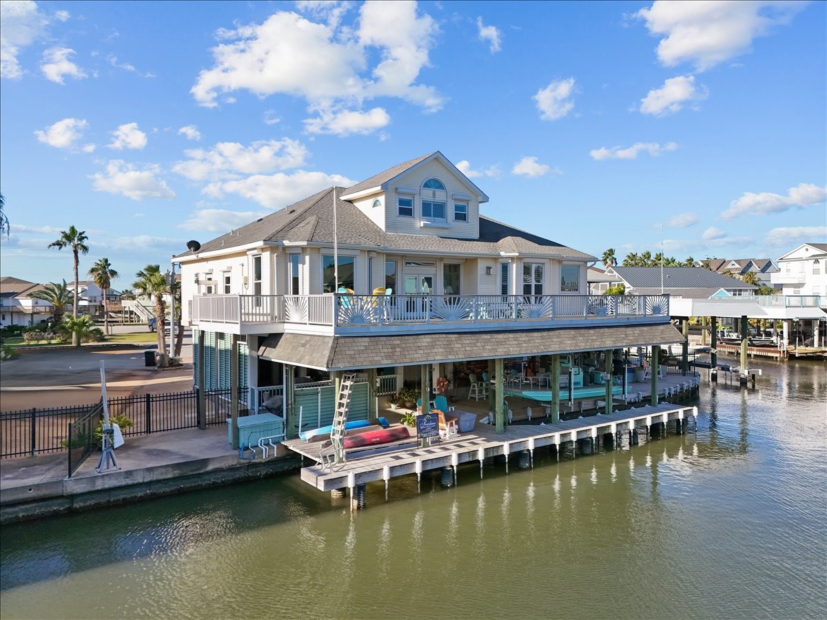 This picturesque view of the back of the home allows you to see the expansive upper deck that has been updated with treated wood, Trex railing and a beautiful sunburst design. There is also a cargo lift on the side of the home that goes down to the ground level next to the garage. The windows have been upgraded and include electric storm shutters except the arched windows.