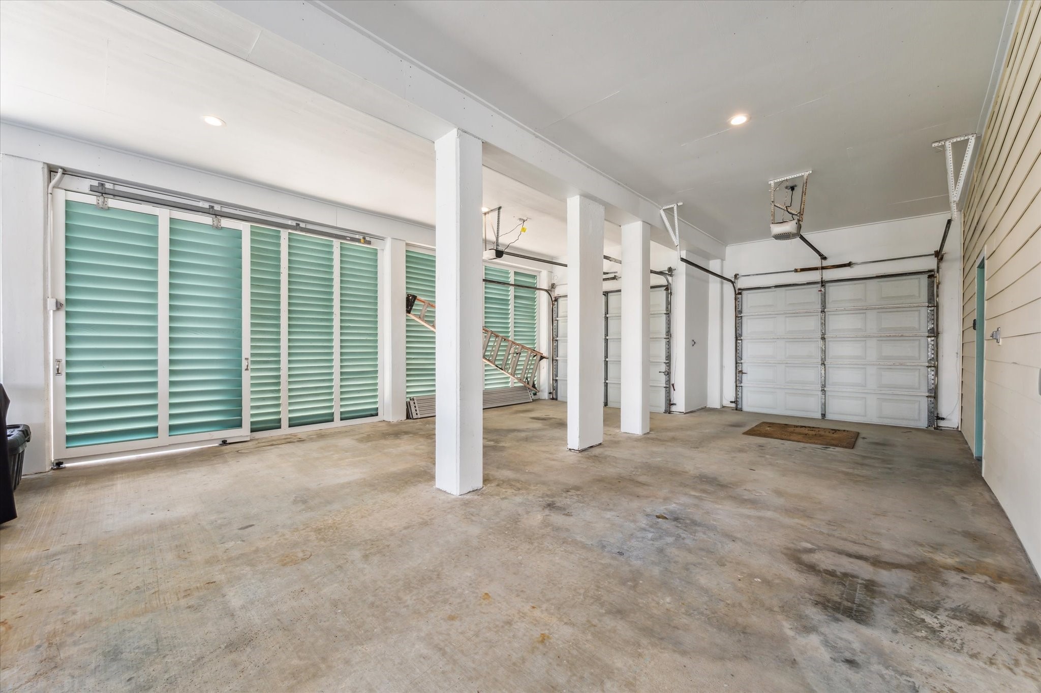 Plenty of space to park in these two garage spaces! Both garage door openers have been recently replaced. Plus one of the louvre screens slides to provide access to the lift to the second level deck.