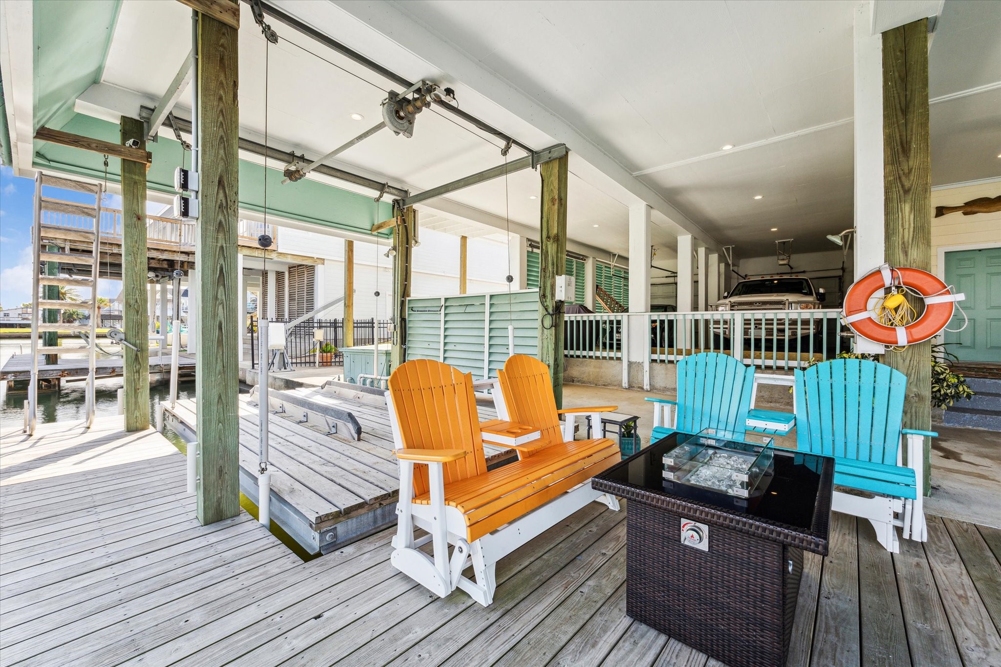 There is no lack of entertaining space or opportunities to enjoy your waterfront views. In between the two boat lifts the owners have created this firepit area. There is also a custom retractable stairway at the end of the deck to make getting in and out of the canal easy.