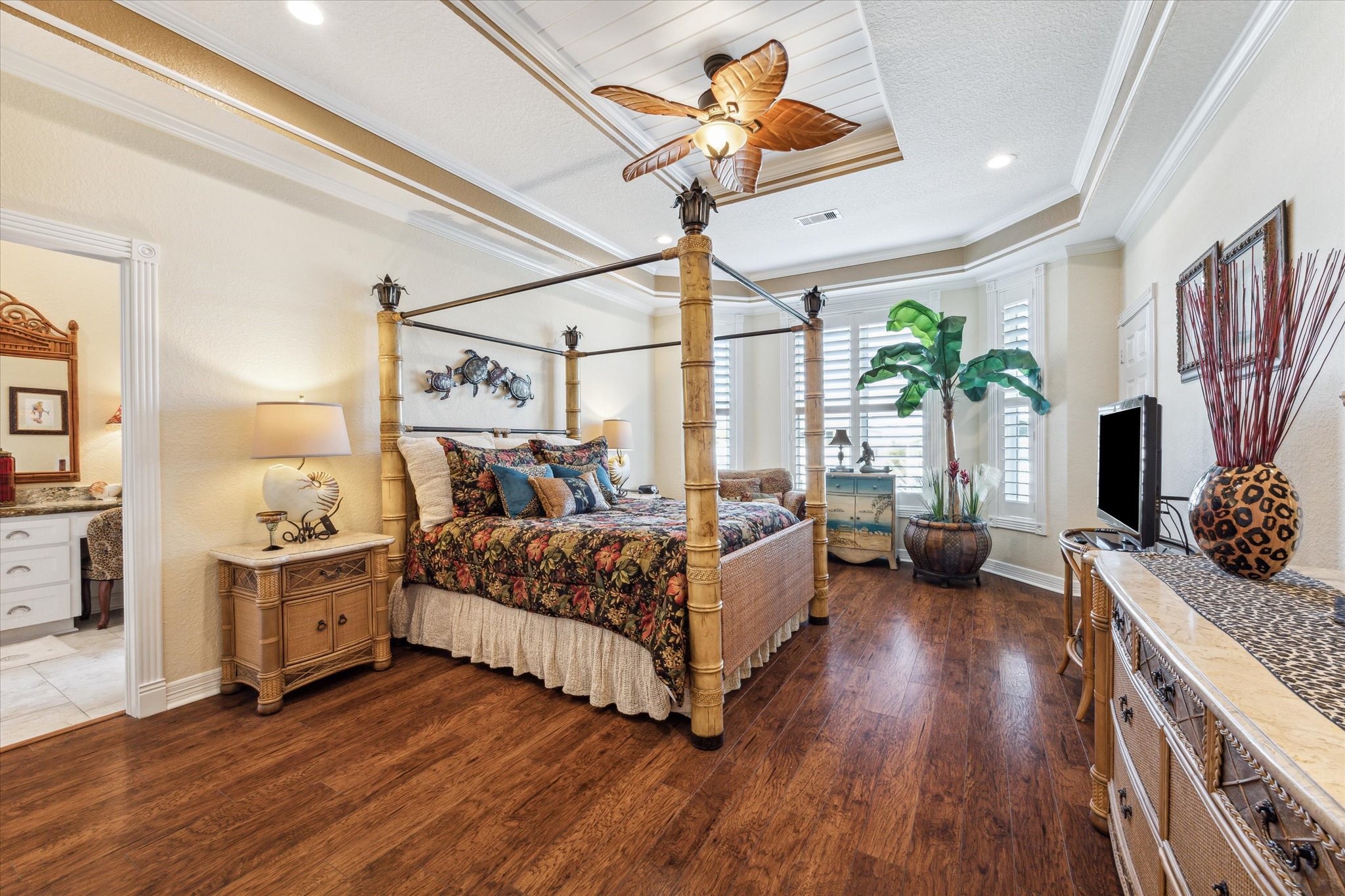 The spacious Primary Bedroom has plenty of room for all of your furniture and boasts beautiful wood floors, bay windows with plantation shutters that overlook the back deck and water, beadboard tray ceiling, crown molding and detailed trim work.