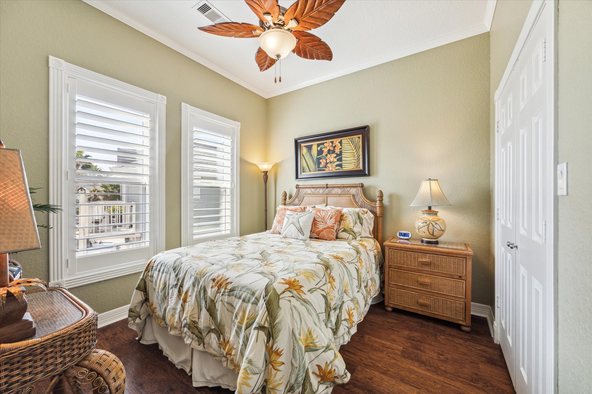 Wood floors continue through to this secondary bedroom which also has detailed trim around the windows, plantation shutters and a custom designed closet.