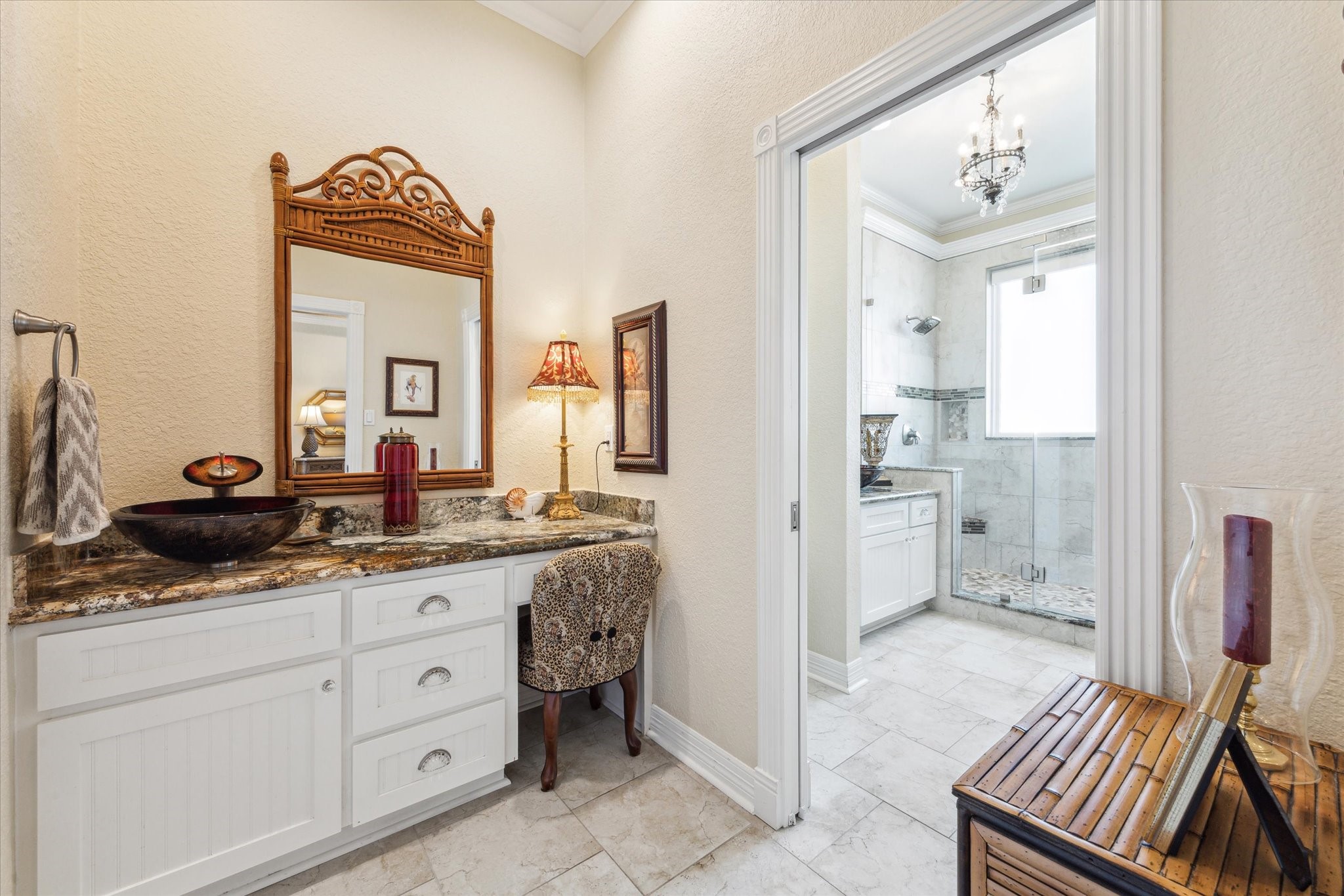 The Primary Bathroom is divided into two rooms. This one has a makeup vanity and vessel sink plus a walk-in closet.