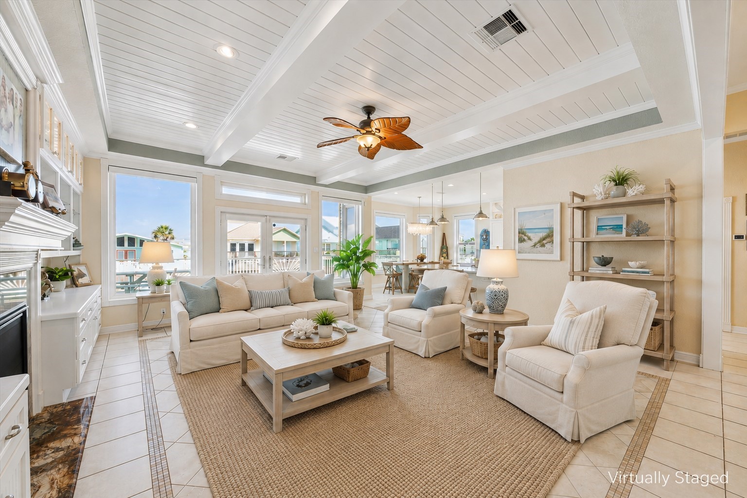 As you enter the elegant, coastal inspired living area (virtually staged in this photo) you are immediately drawn to the wall of windows and French doors leading out to the massive deck overlooking the canal. The beadboard ceiling, beams and extensive trim and molding add to the design.