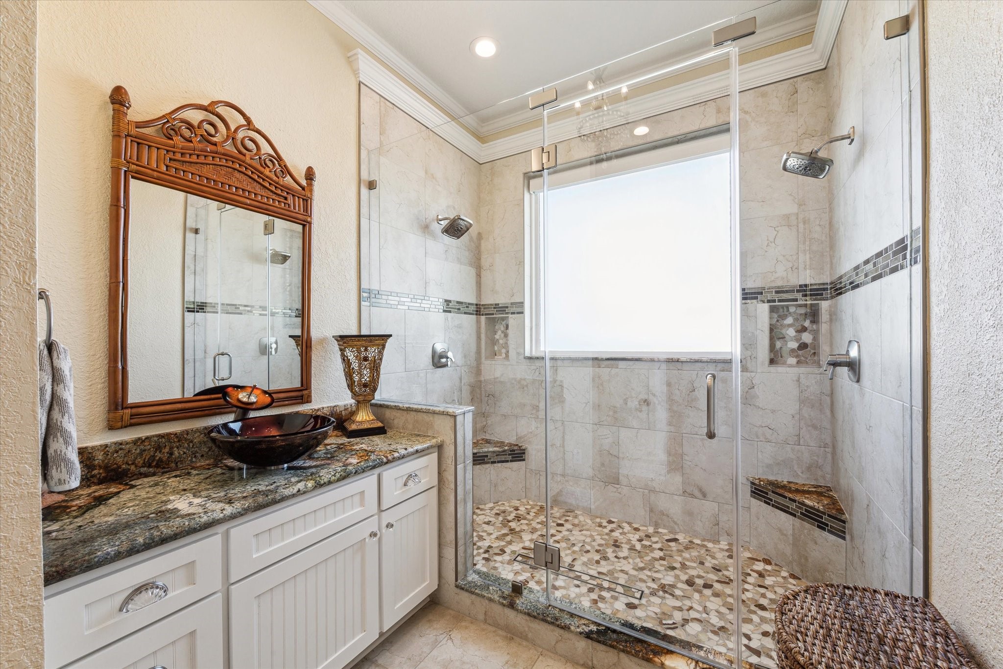 The second area of the Primary Bathroom offers a large walk-in shower with two benches, 2 rain shower heads, a second vanity with vessel sink and the toilet.